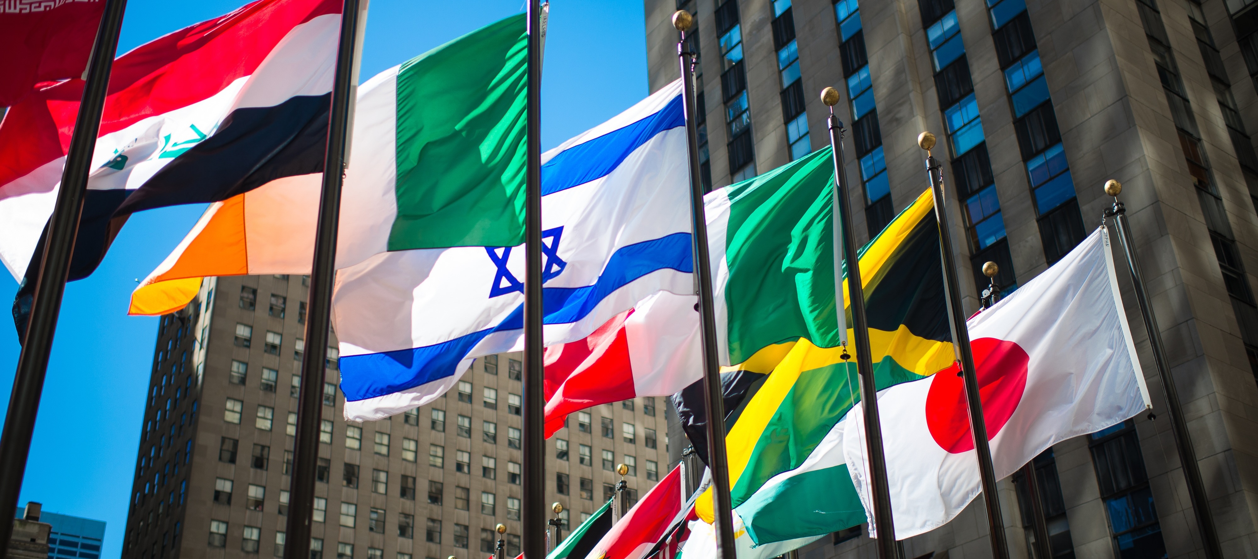 International flags waving against blue sky