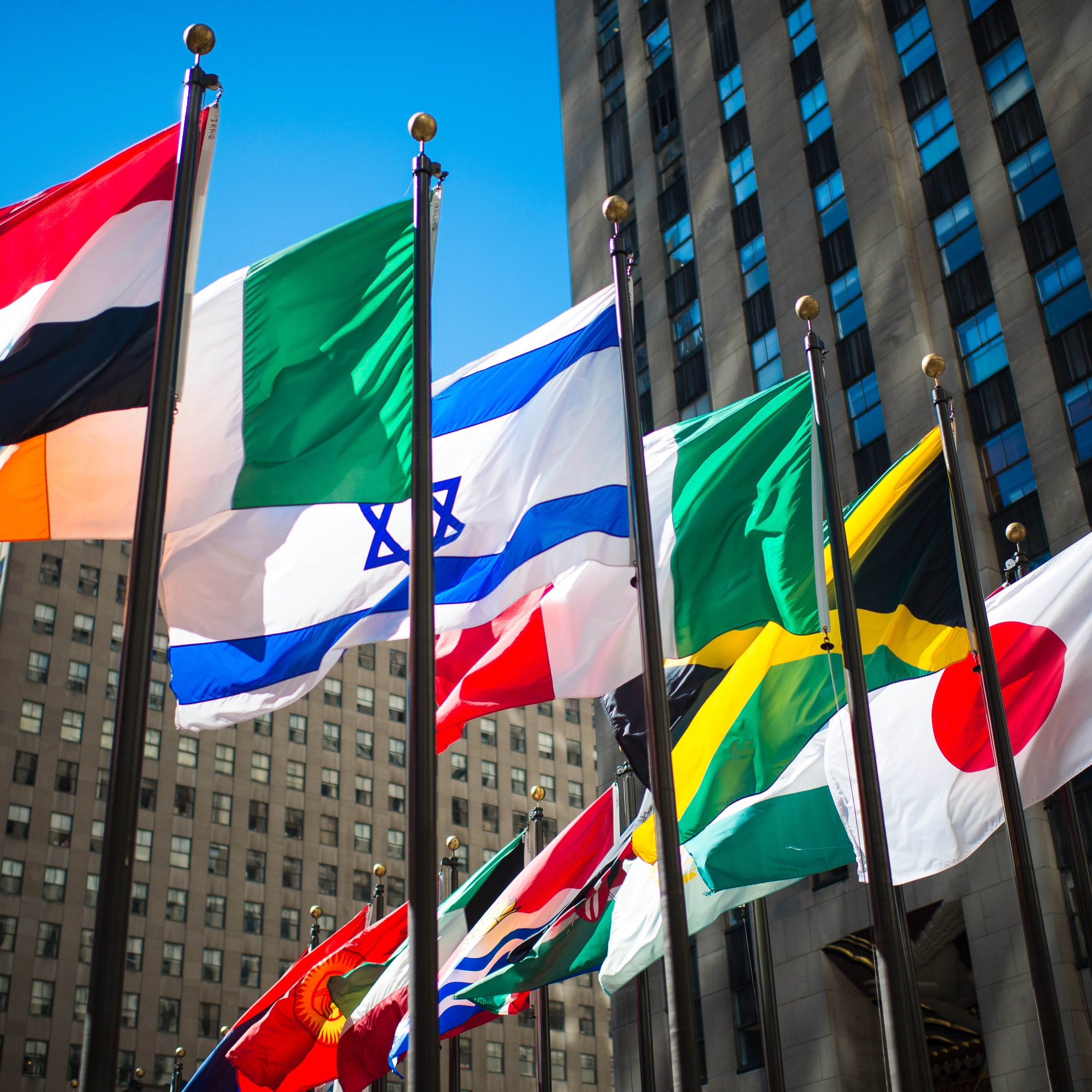 International flags waving against blue sky