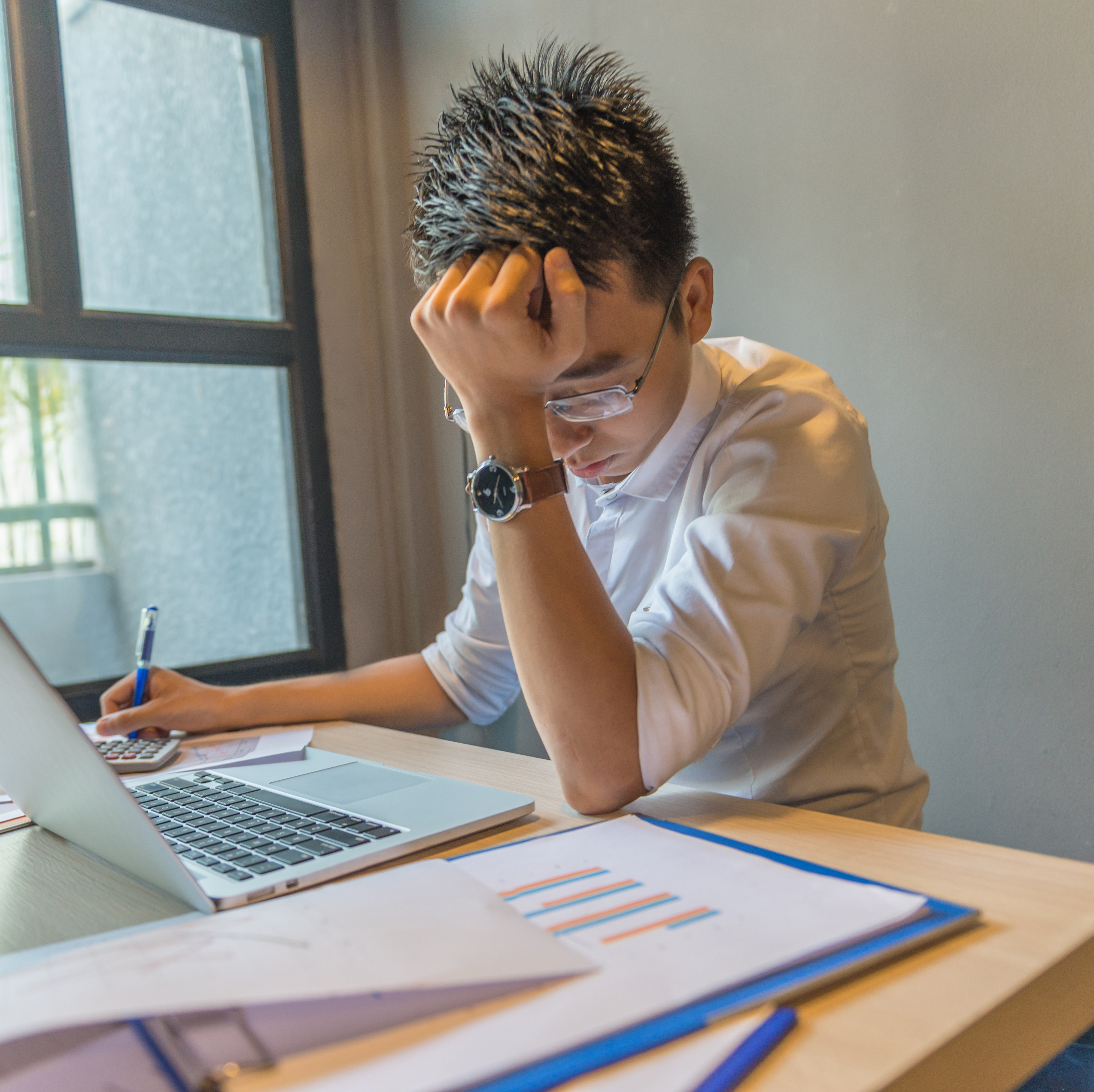 A young man working hard on his computer.