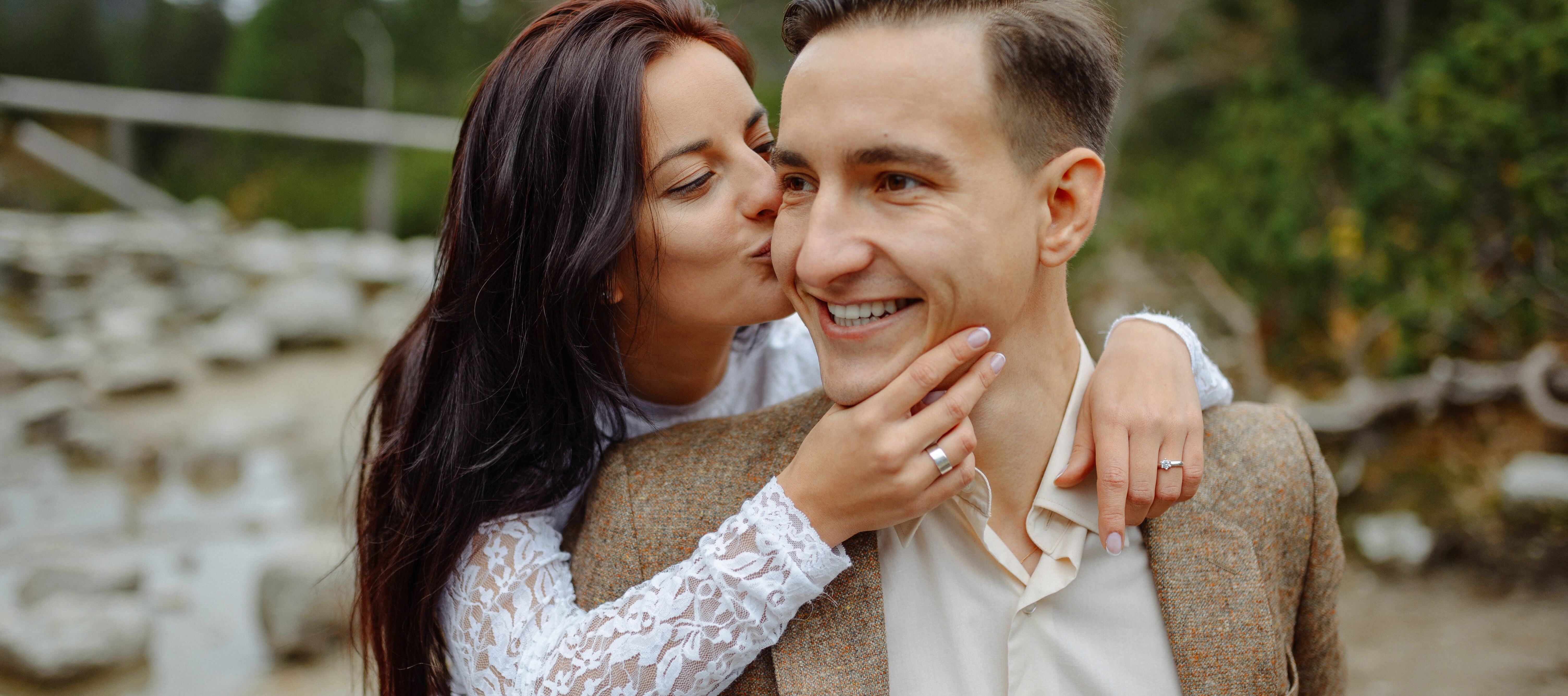 Young engaged couple smiling and posing outside