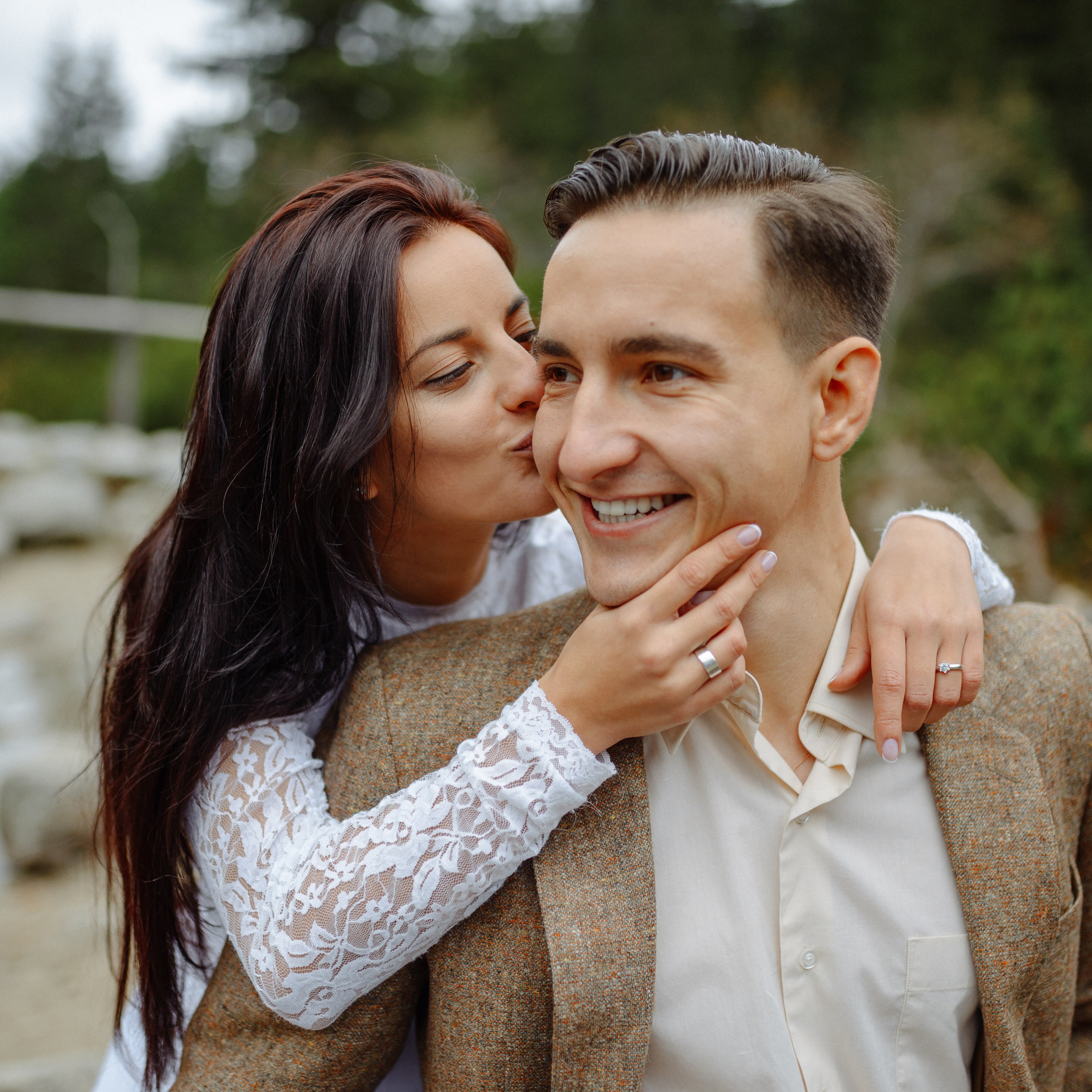 Young engaged couple smiling and posing outside