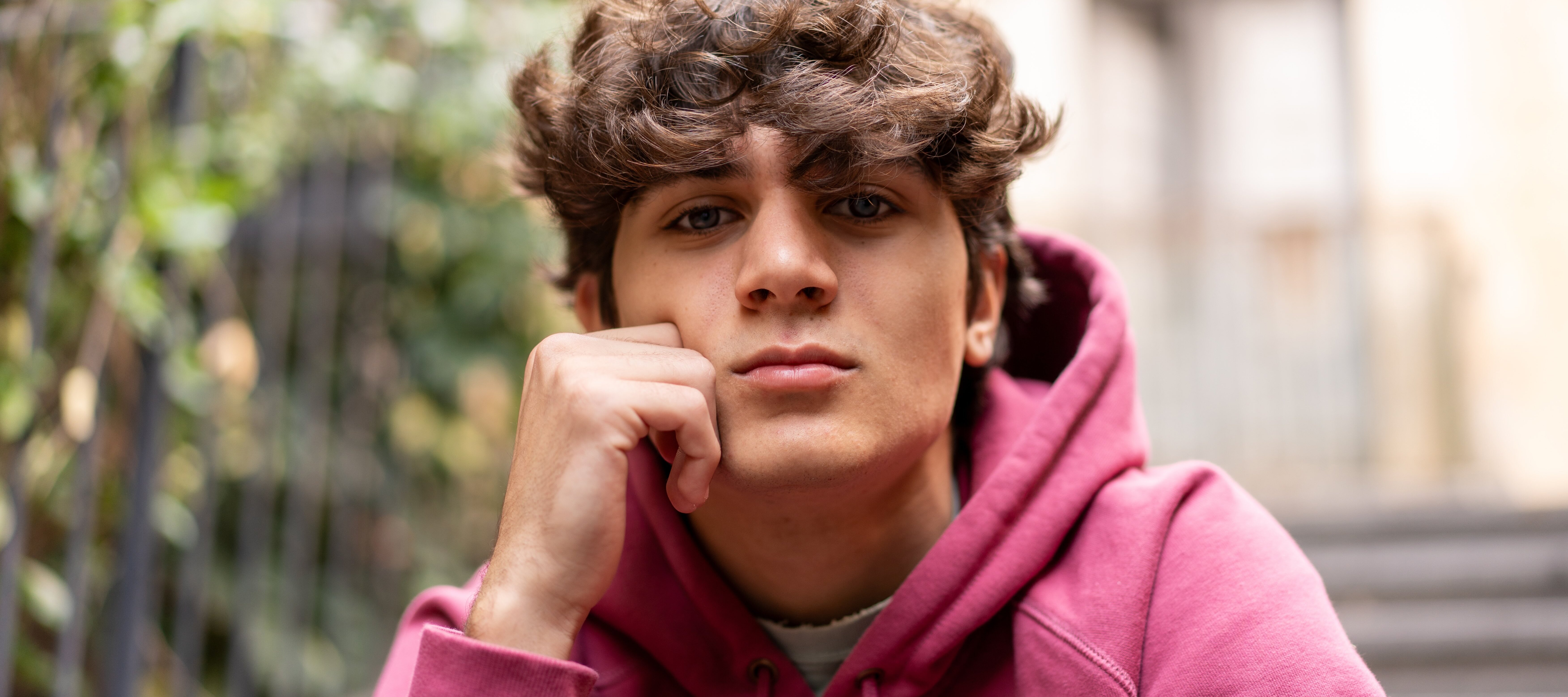 Thoughtful teen boy sitting outside