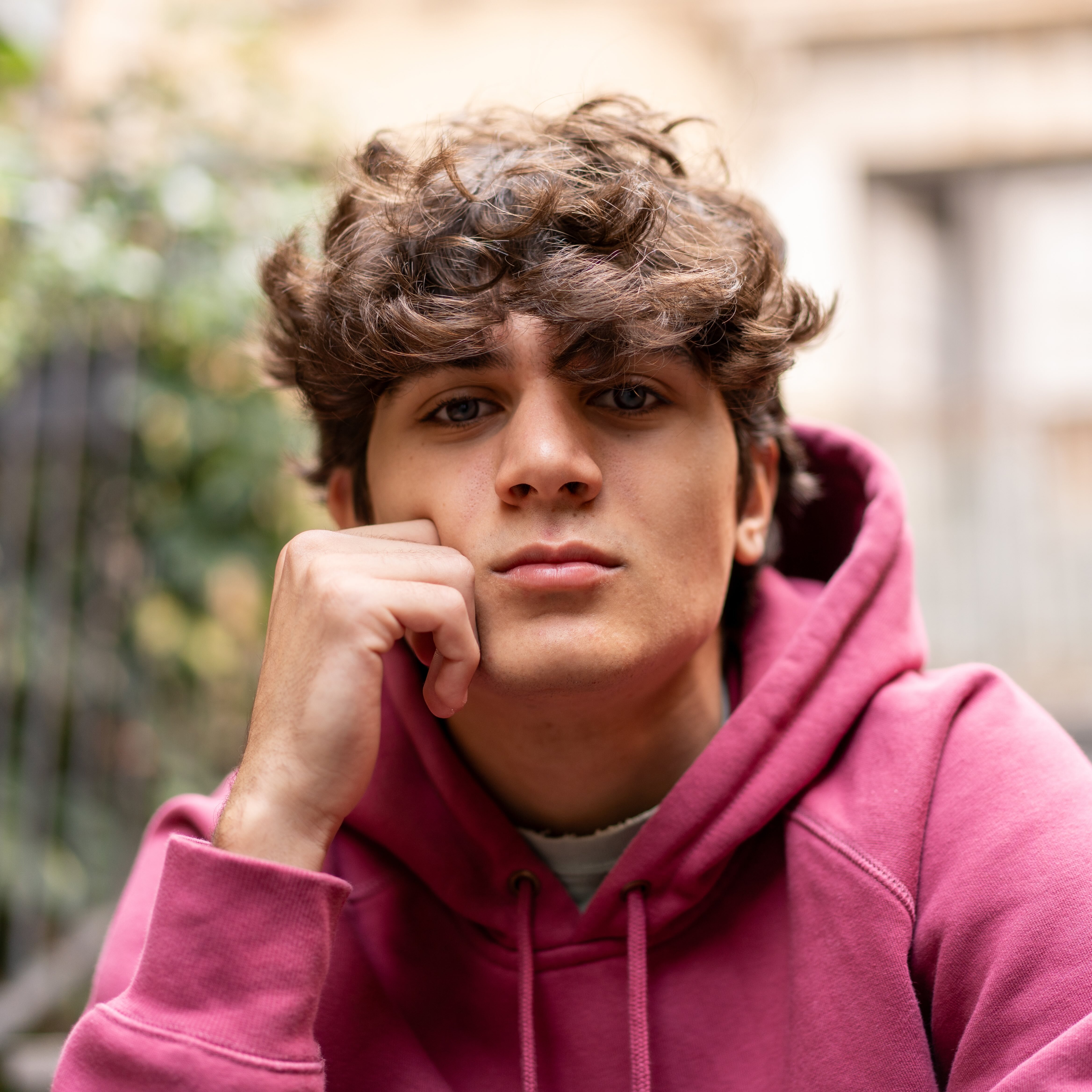 Thoughtful teen boy sitting outside
