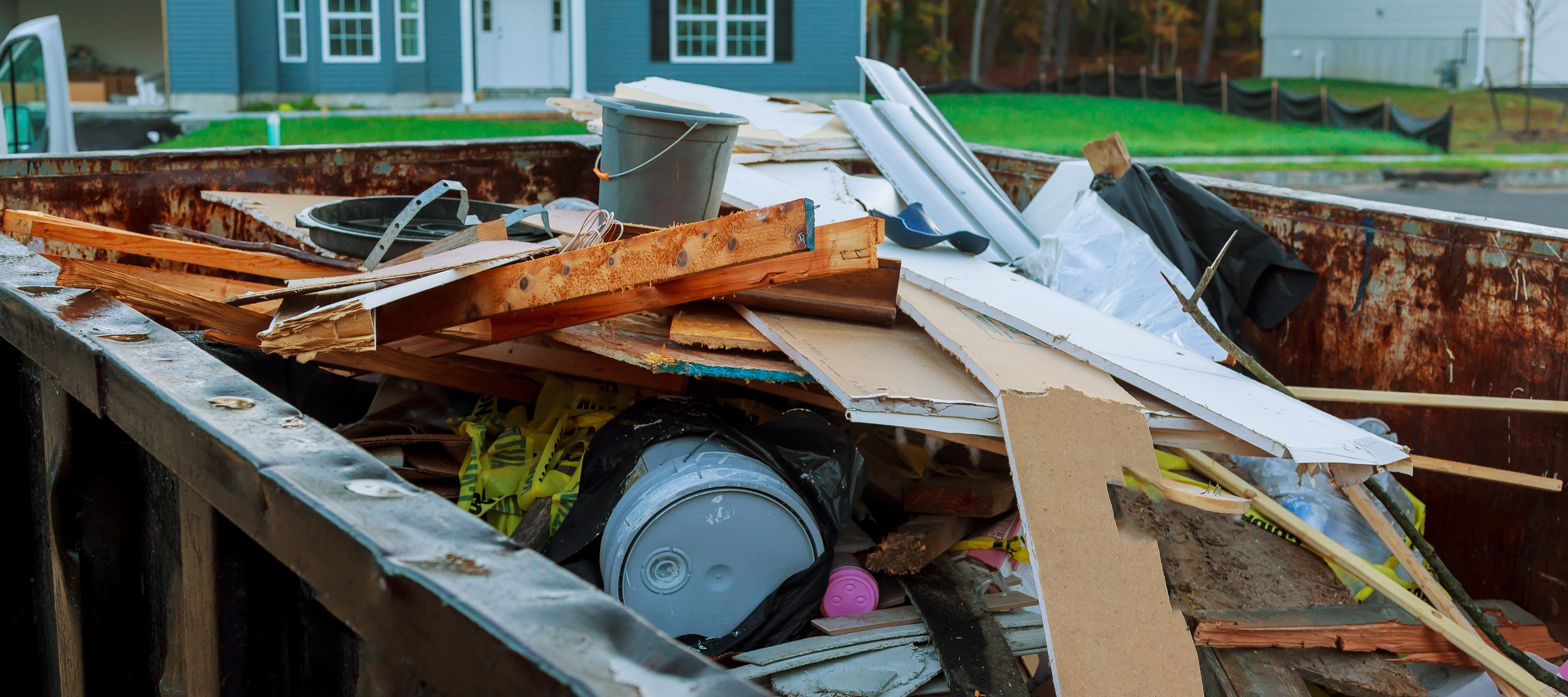 Construction debris in dump truck parked outside house