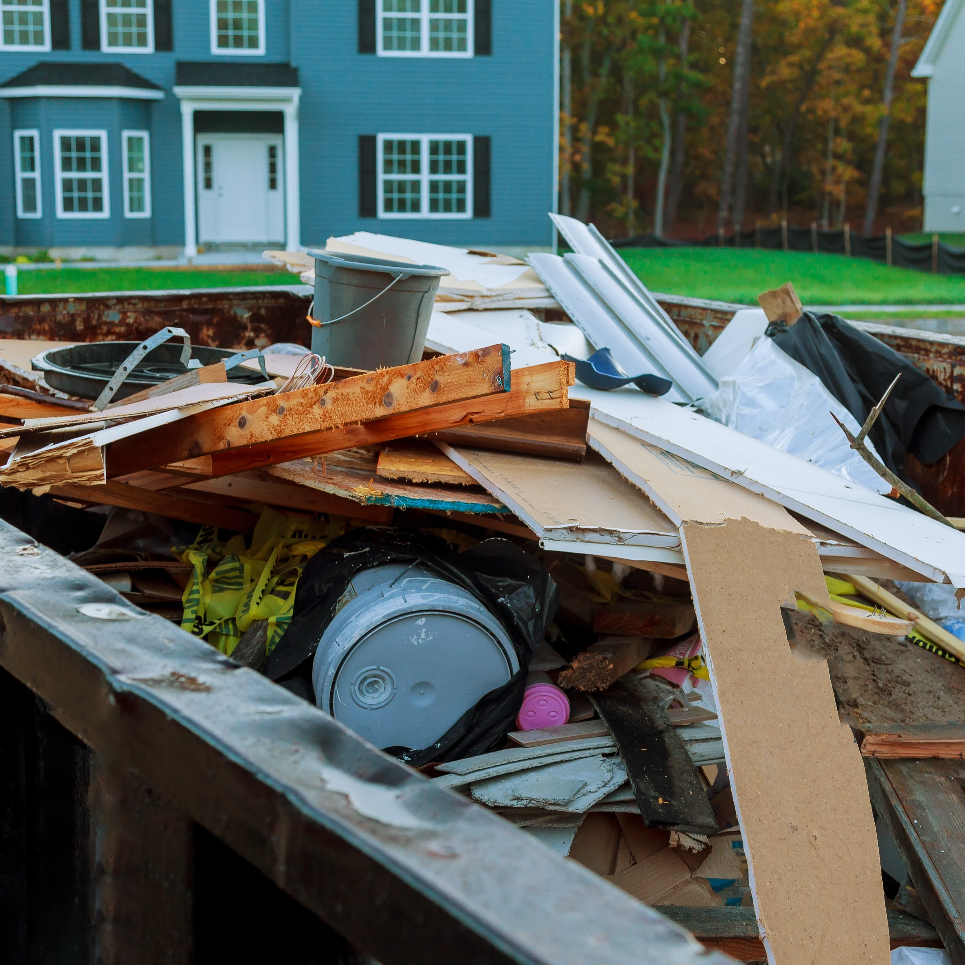 Construction debris in dump truck parked outside house