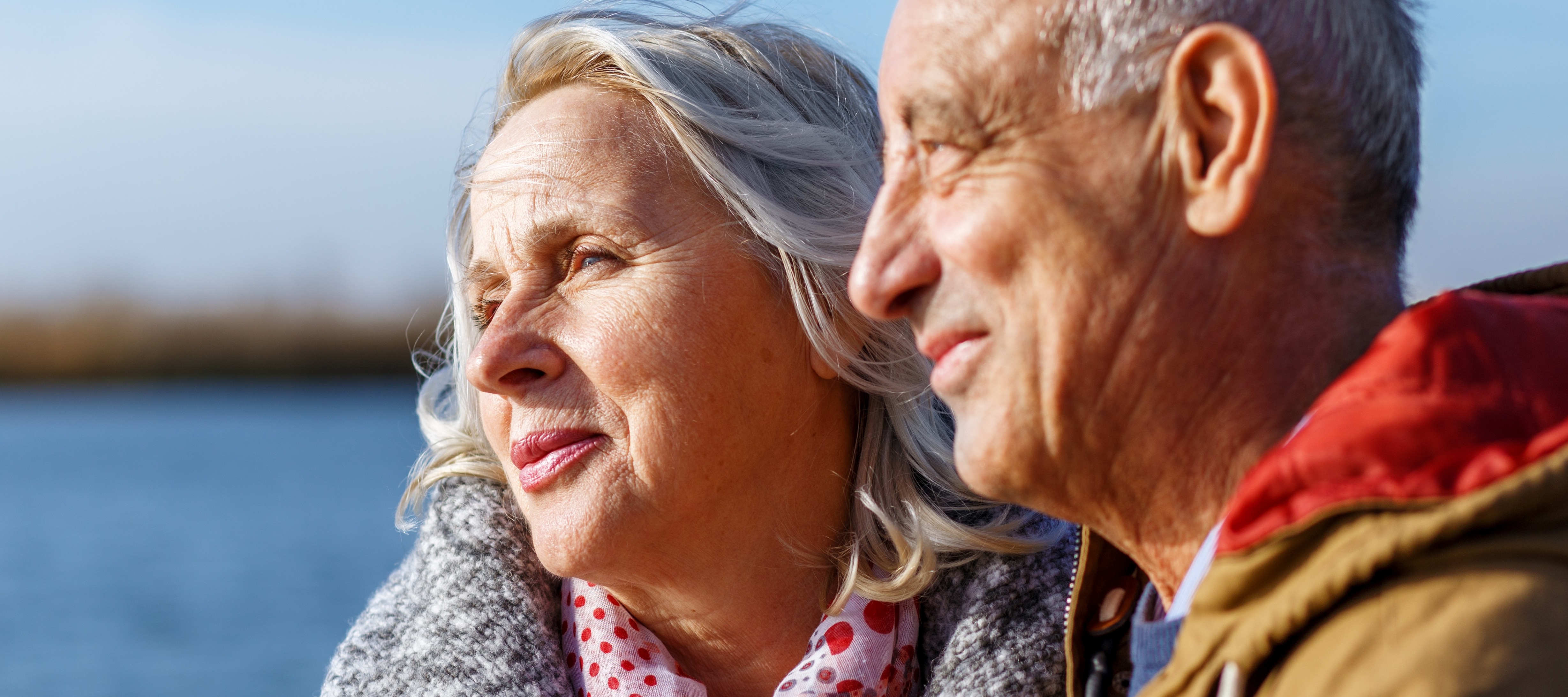 Older couple smiling by lake