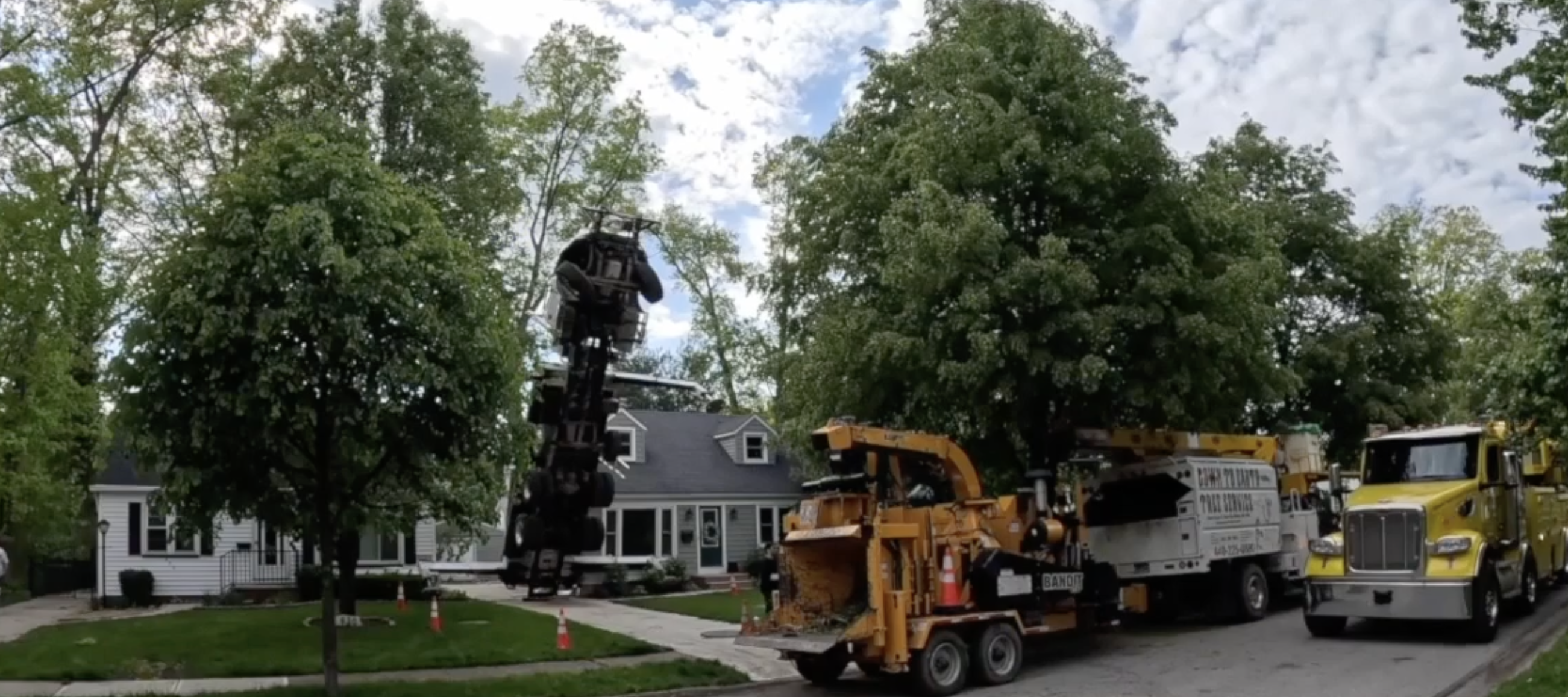 A tree company's crane tips up into the air in an Ohio neighborhood.