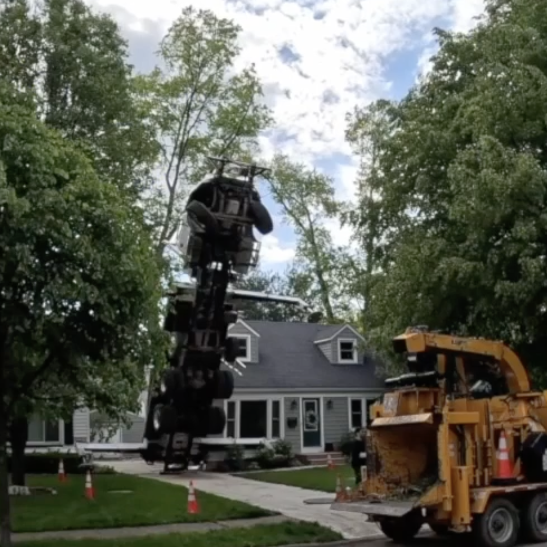 A tree company's crane tips up into the air in an Ohio neighborhood.