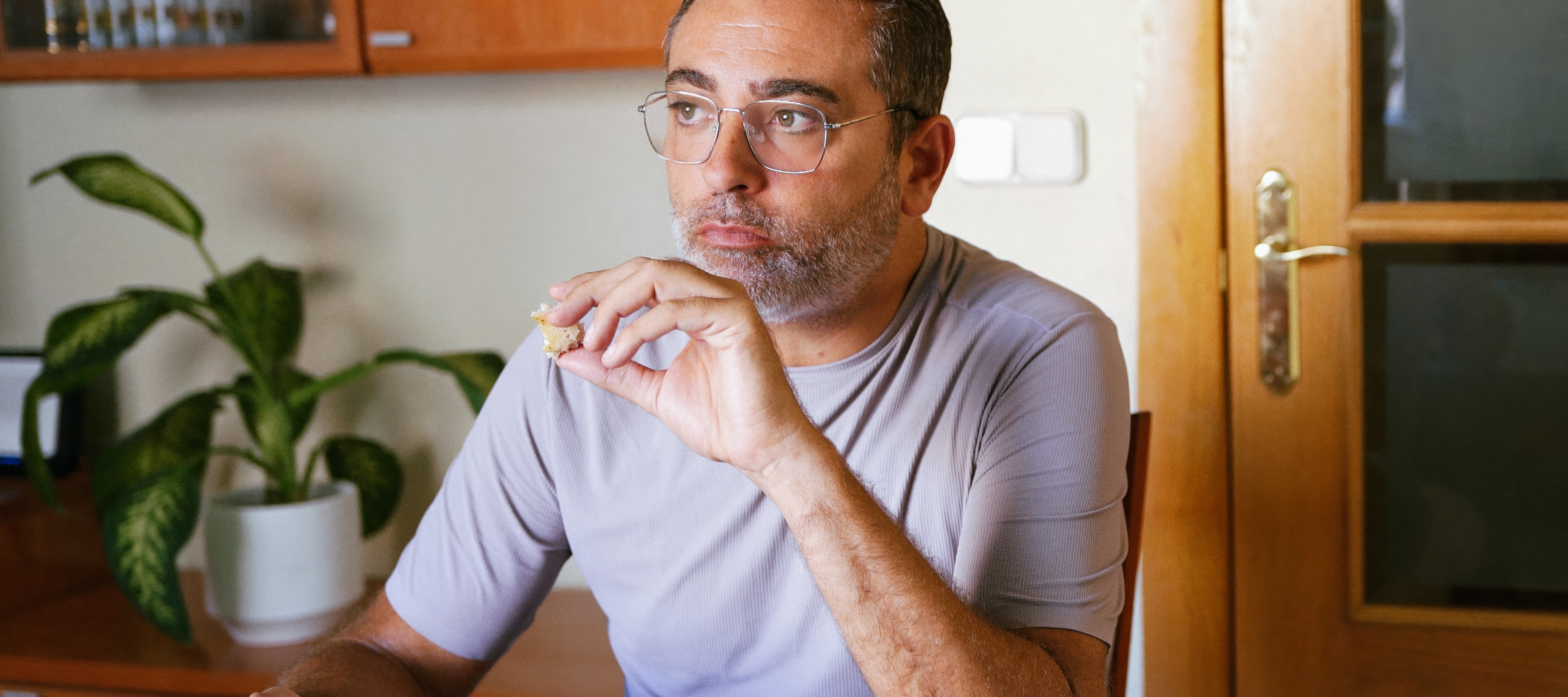 Middle age man eating and thinking at dining room table