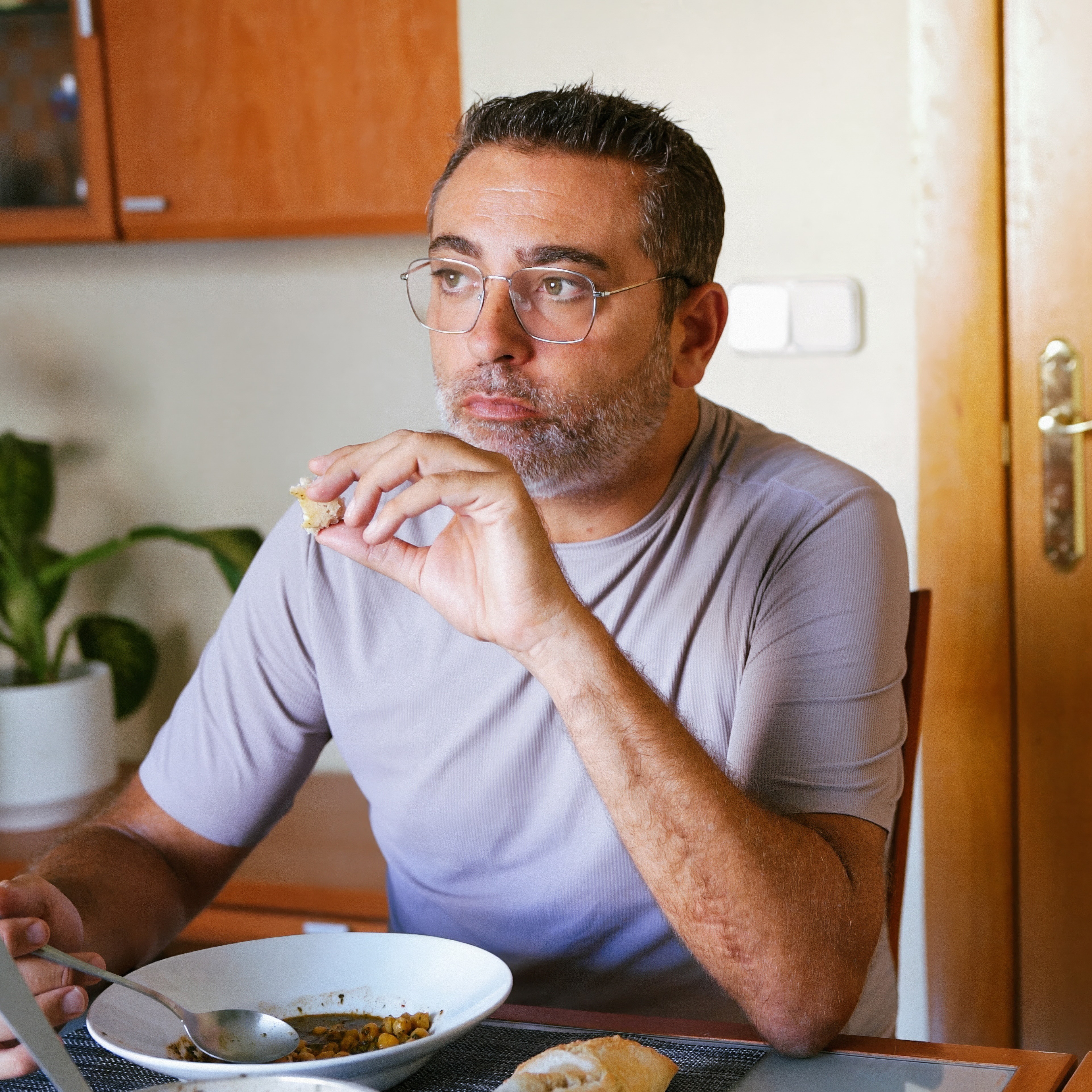 Middle age man eating and thinking at dining room table
