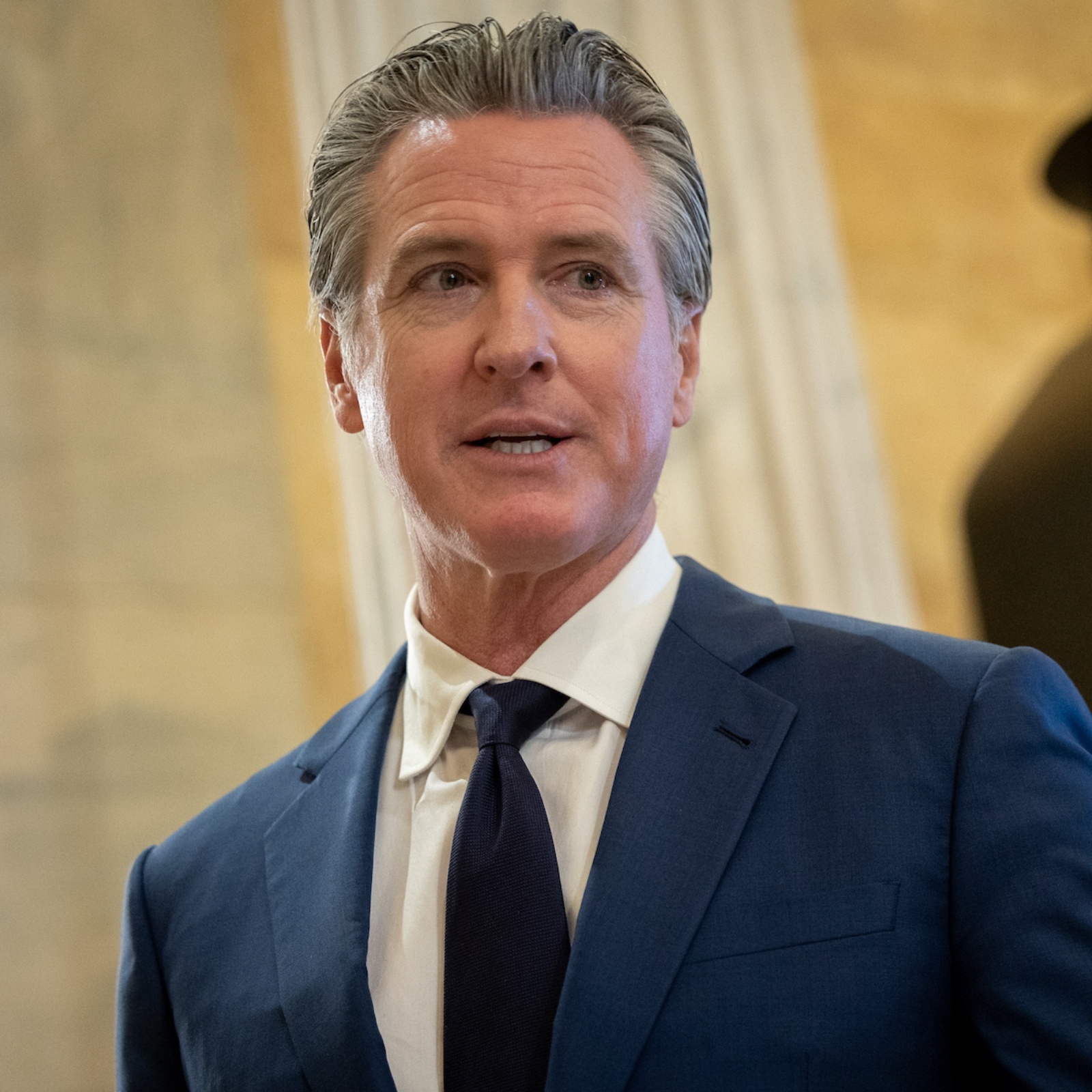 L: Gavin Newsom, R: TOP TIER gasoline label at gas pump