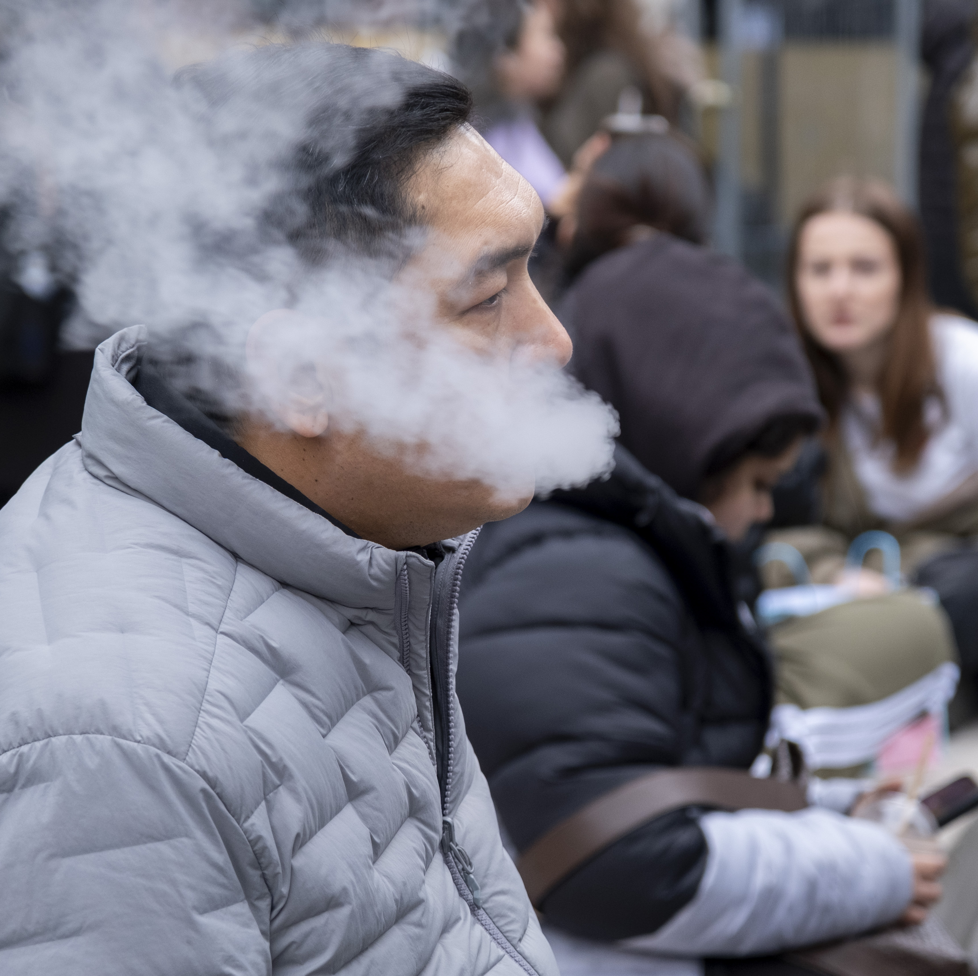 A man vaping on the street.