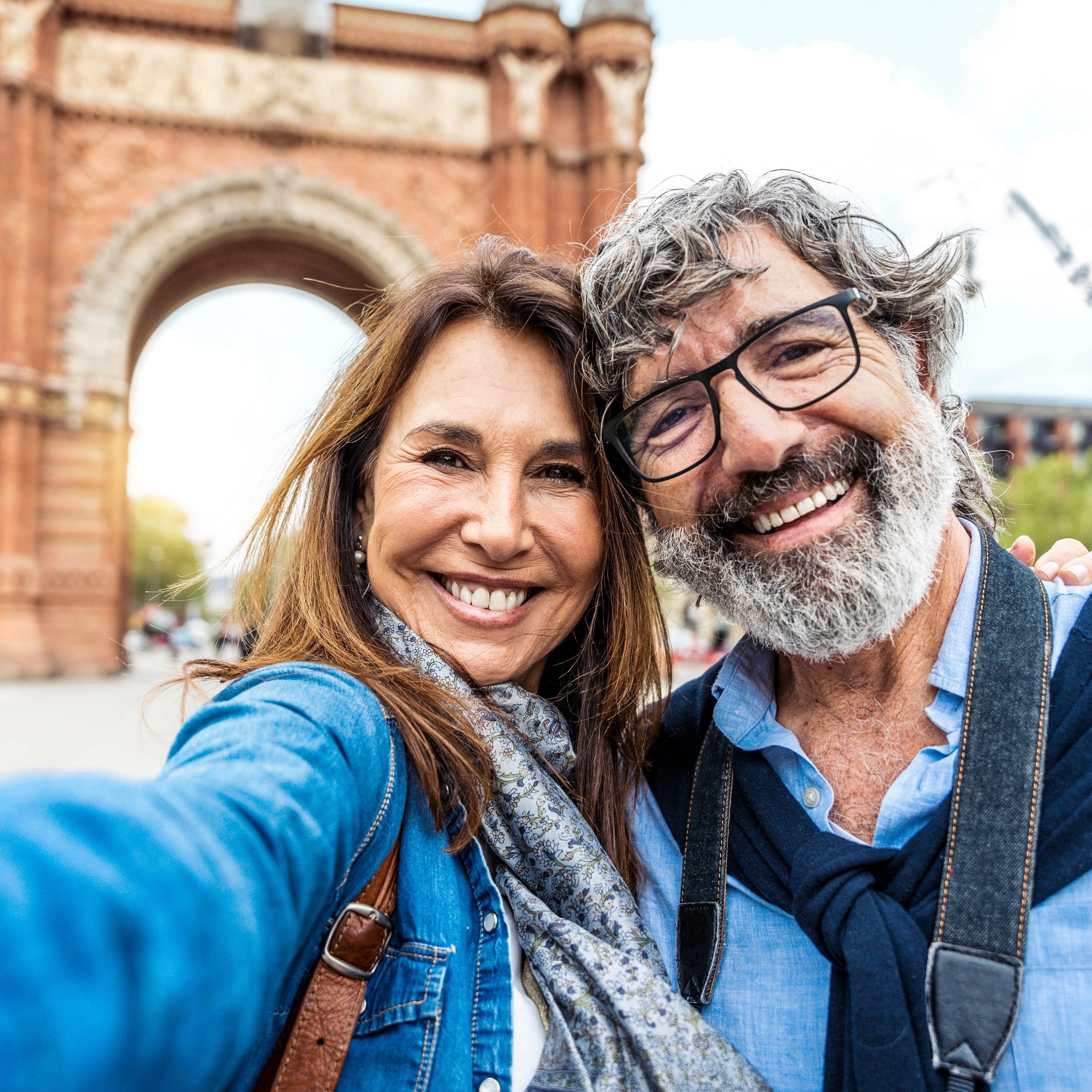 Married older happy couple taking selfie in front of Triumphal Arch in Barcelona, Catalonia, Spain.