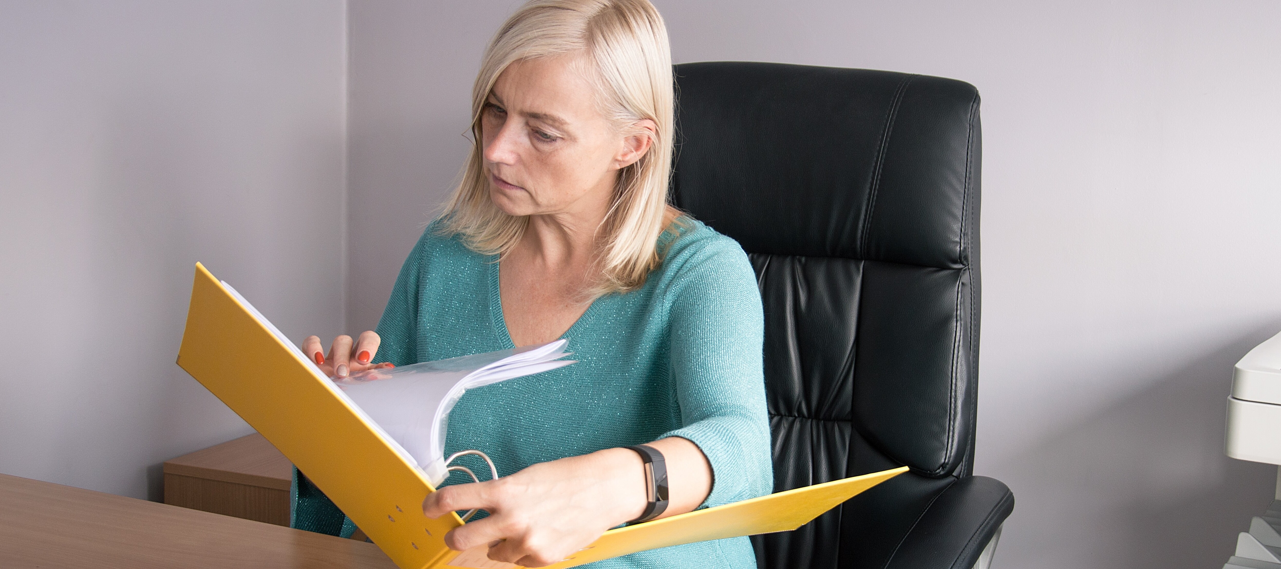 Middle age woman going through binder of old files