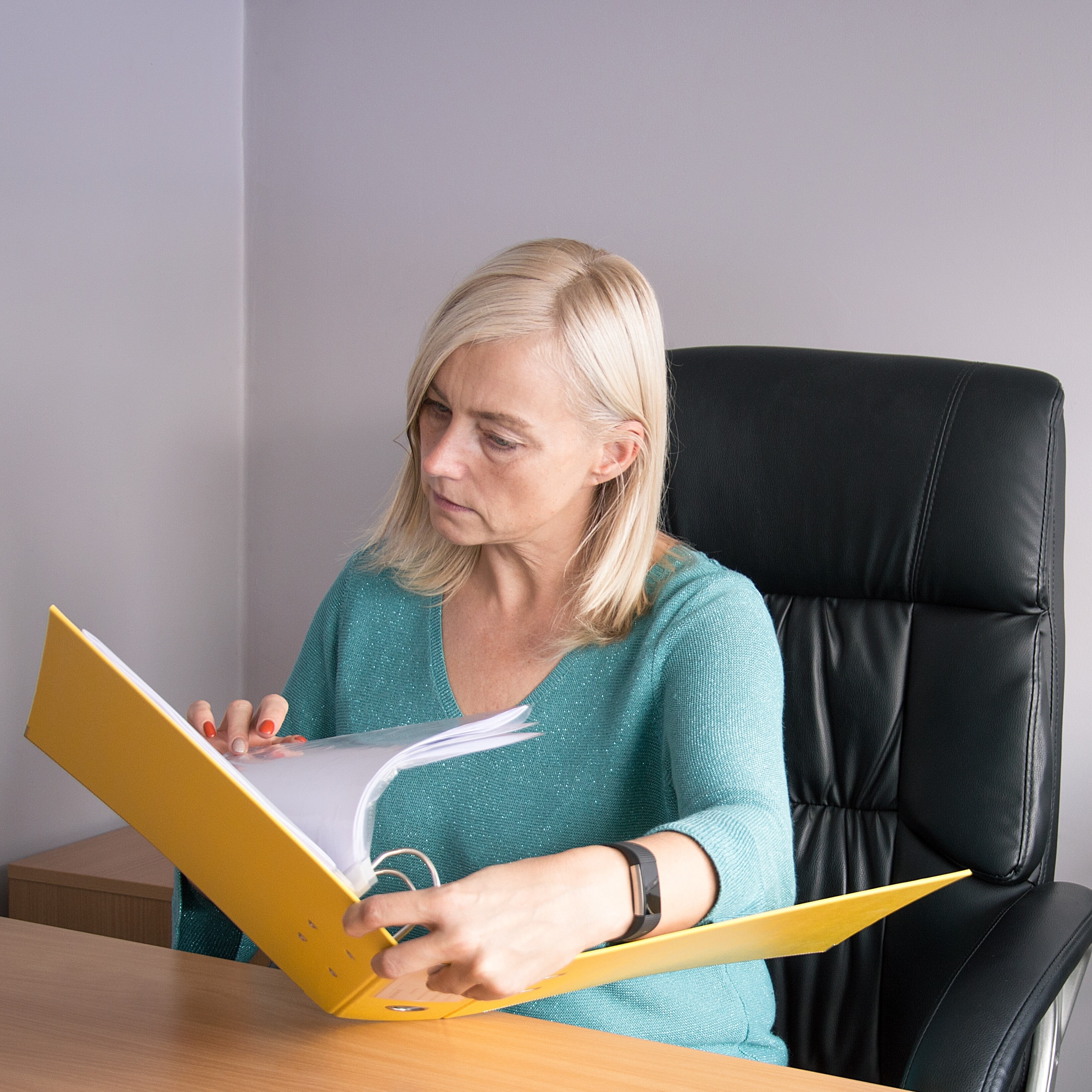 Middle age woman going through binder of old files