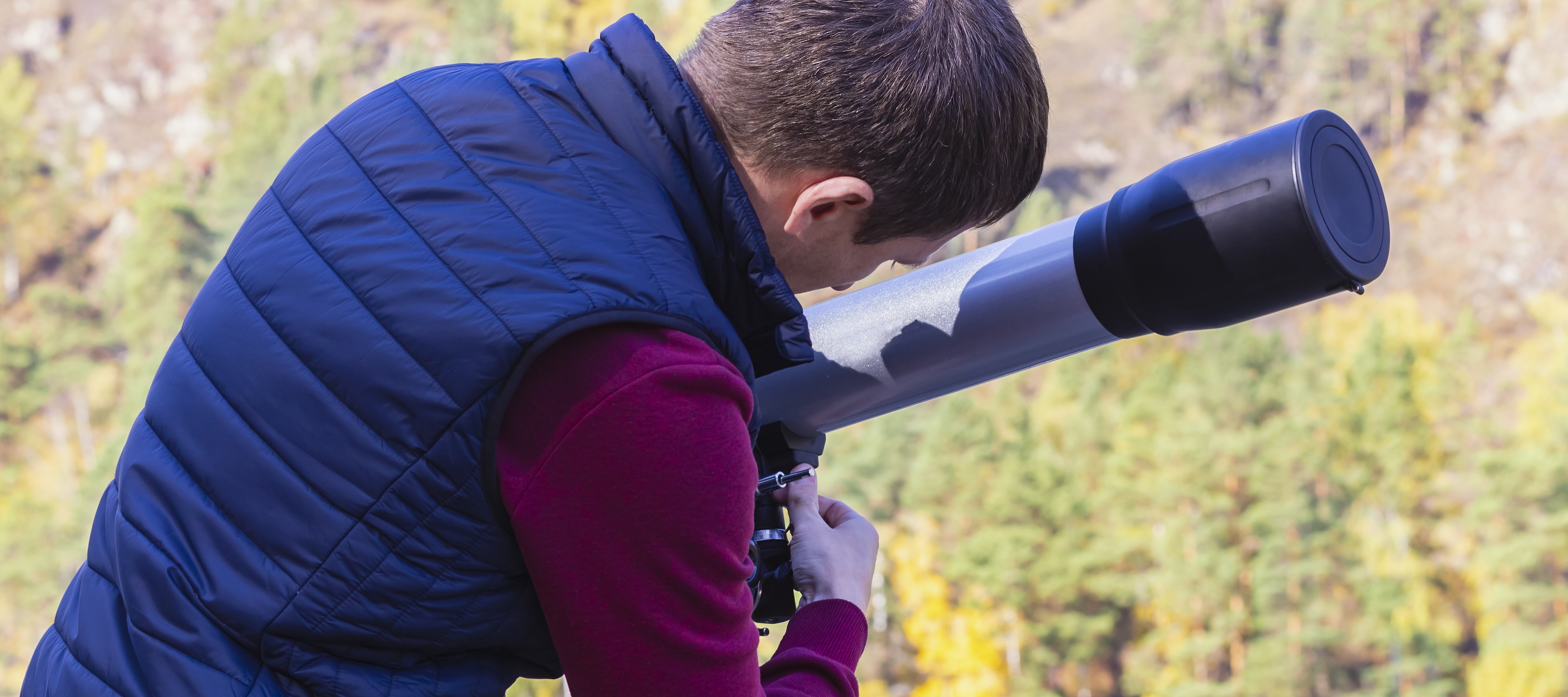Man setting up telescope outside