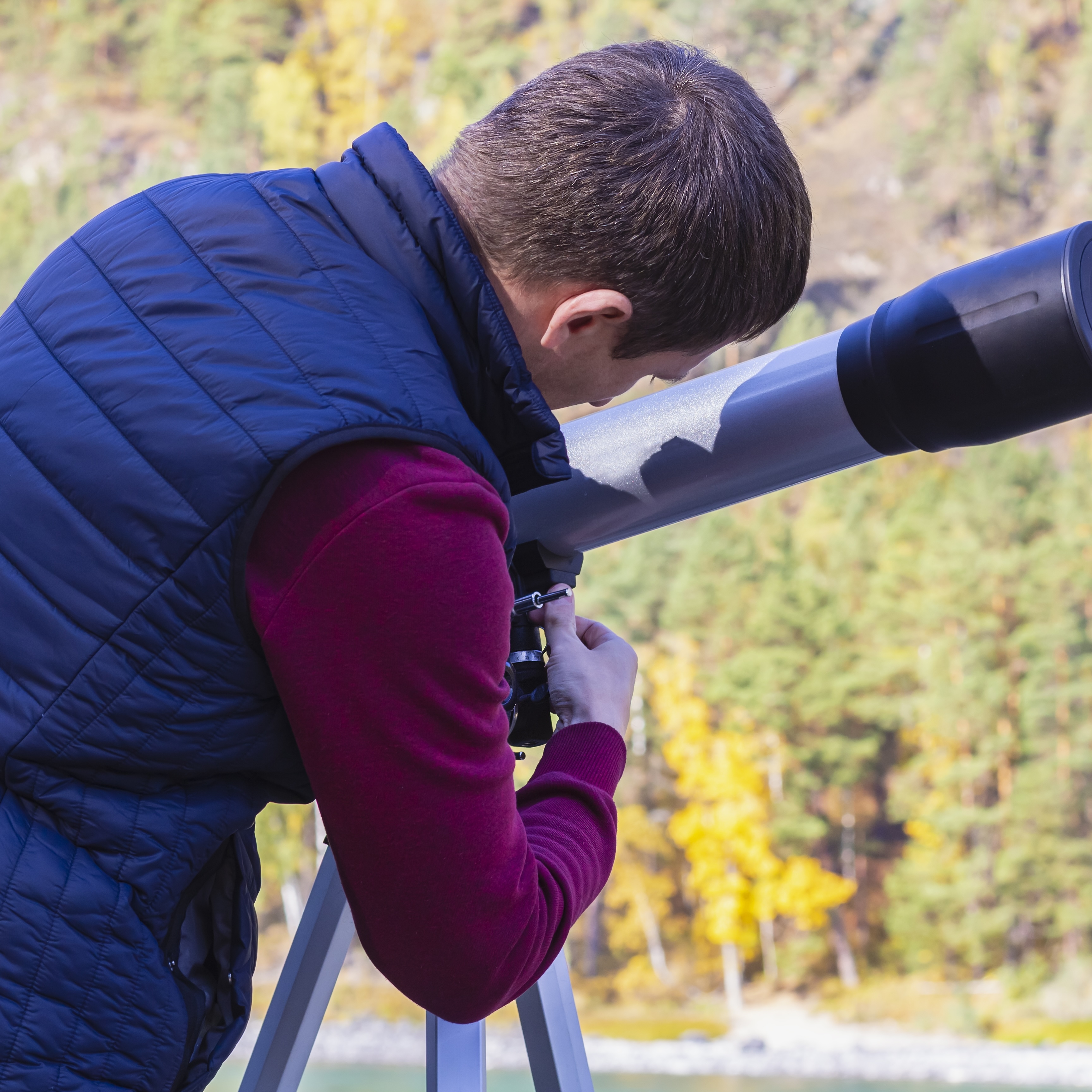 Man setting up telescope outside