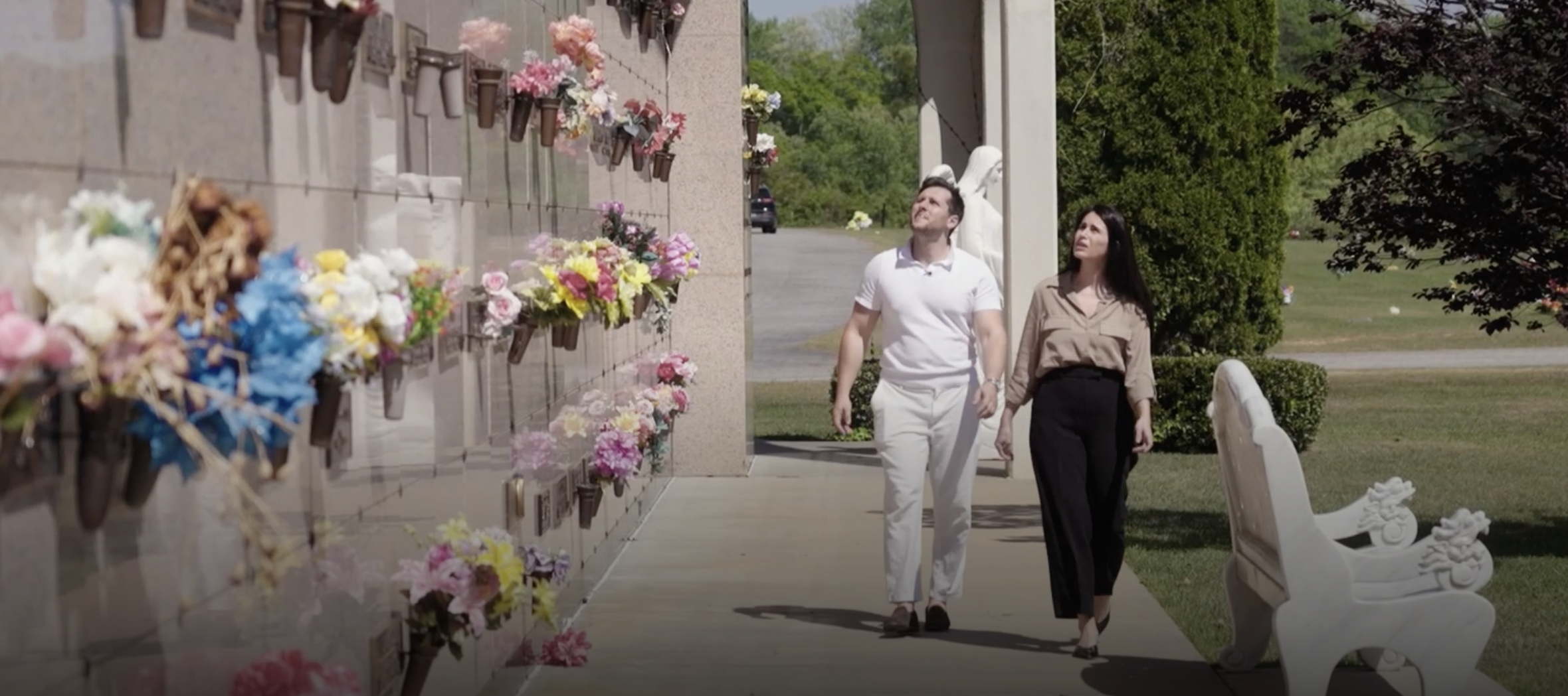 Timothy Amoui and Shayda Frost walking through their cemetery.