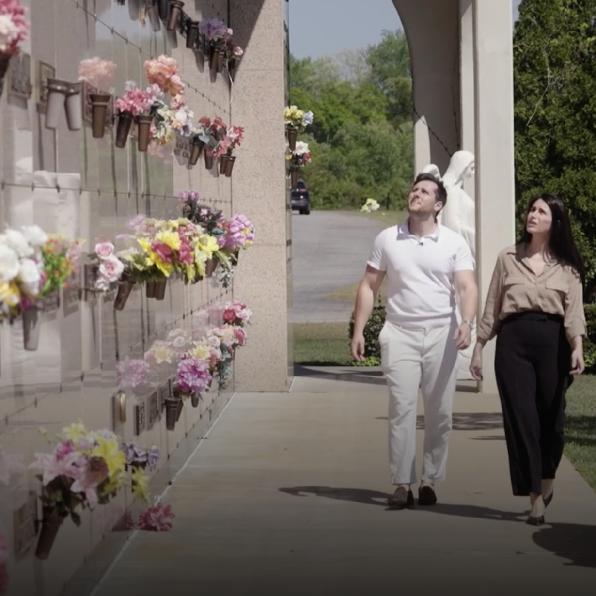 Timothy Amoui and Shayda Frost walking through their cemetery.