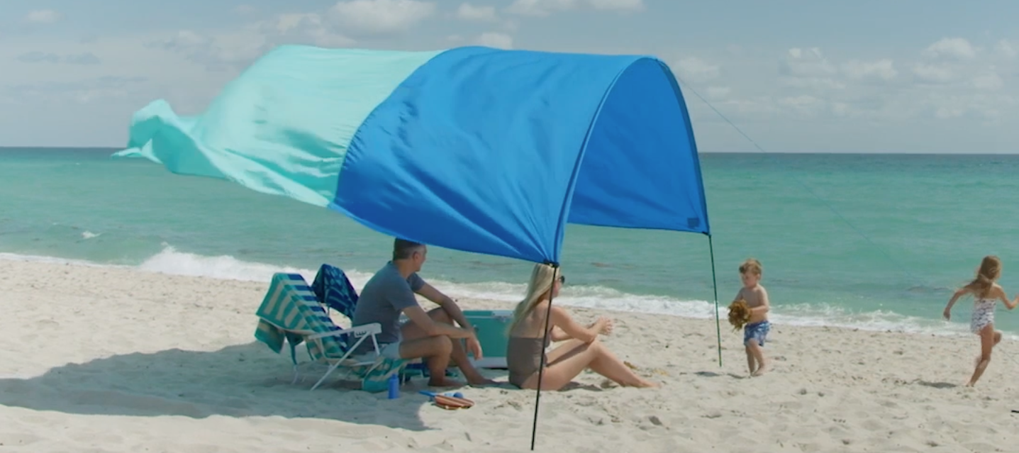 Family enjoying a beach day under a Shibumi Shade.