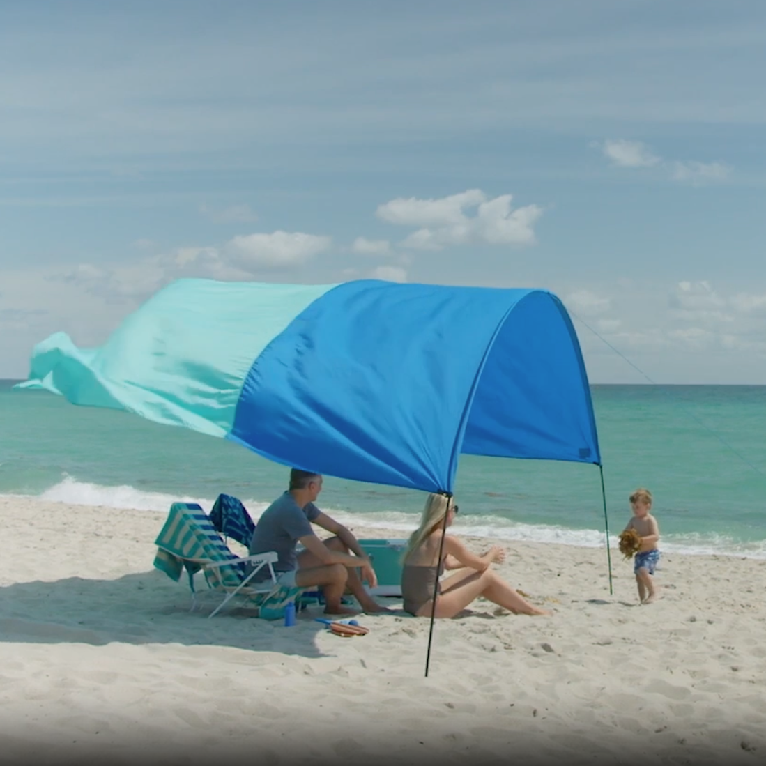 Family enjoying a beach day under a Shibumi Shade.