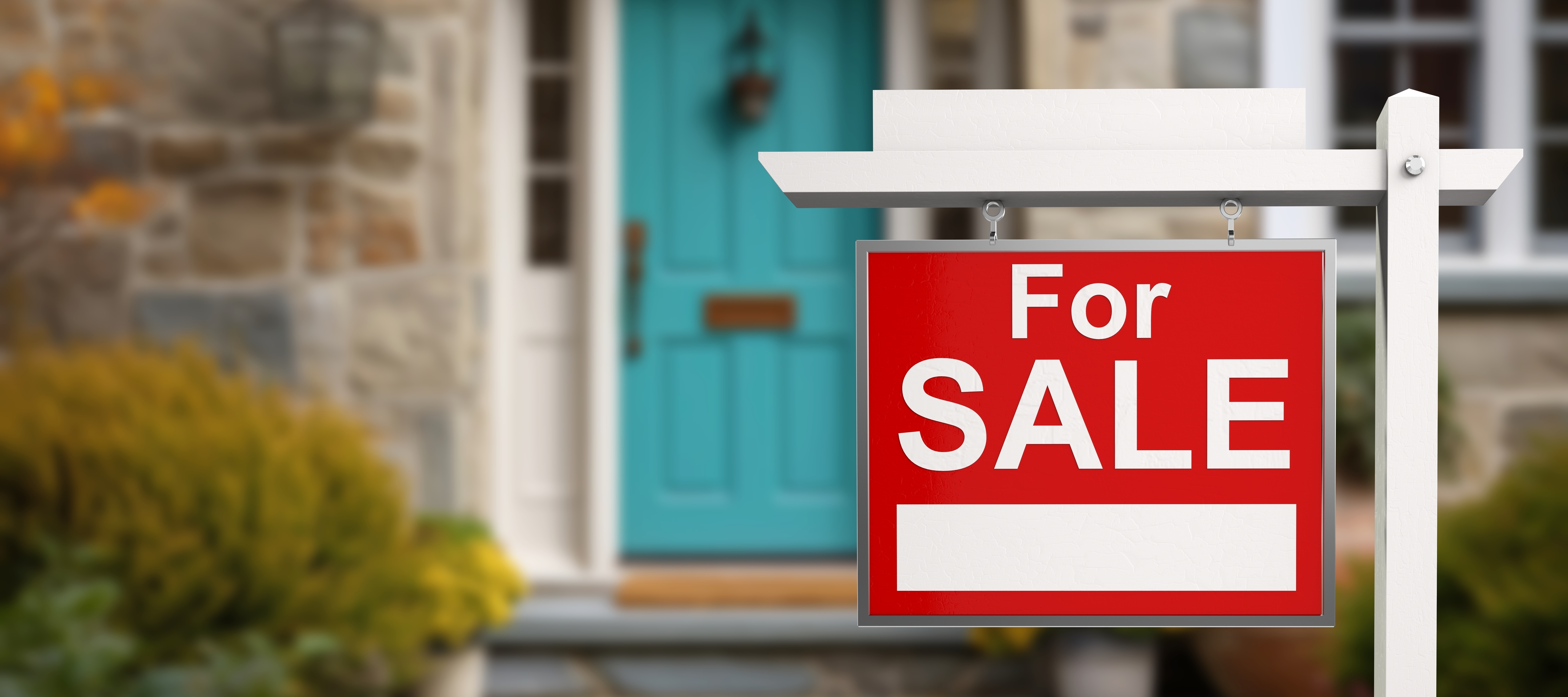 For sale sign posted by real estate agency on street