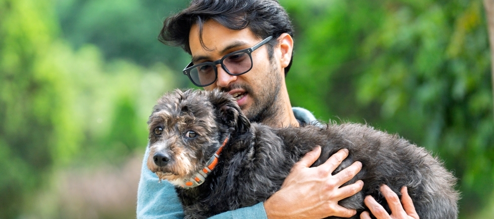 A photo of a man holding a pet dog