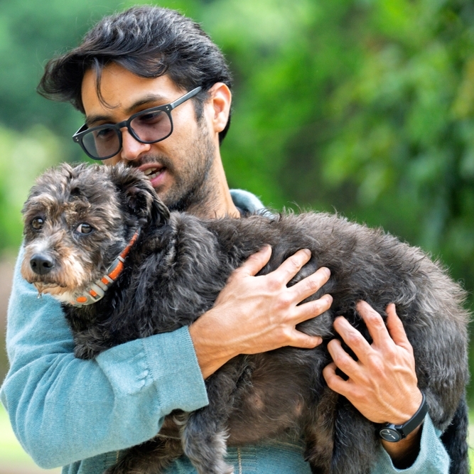 A photo of a man holding a pet dog