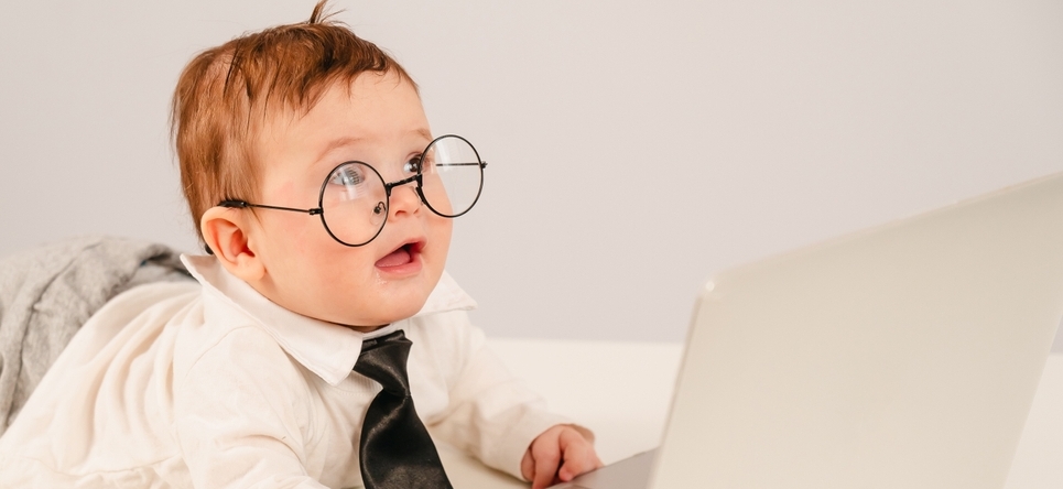 Photo of baby in glasses at laptop