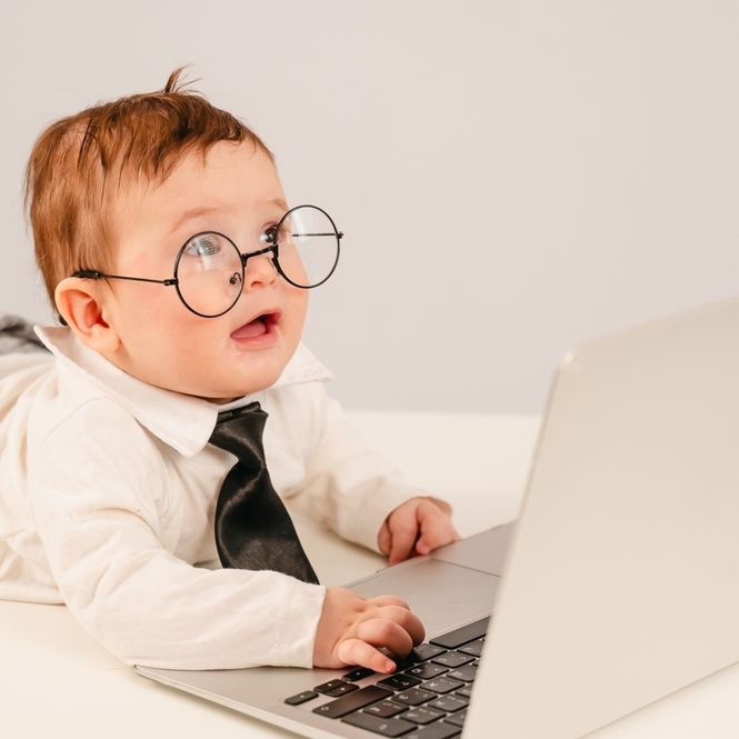 Photo of baby in glasses at laptop