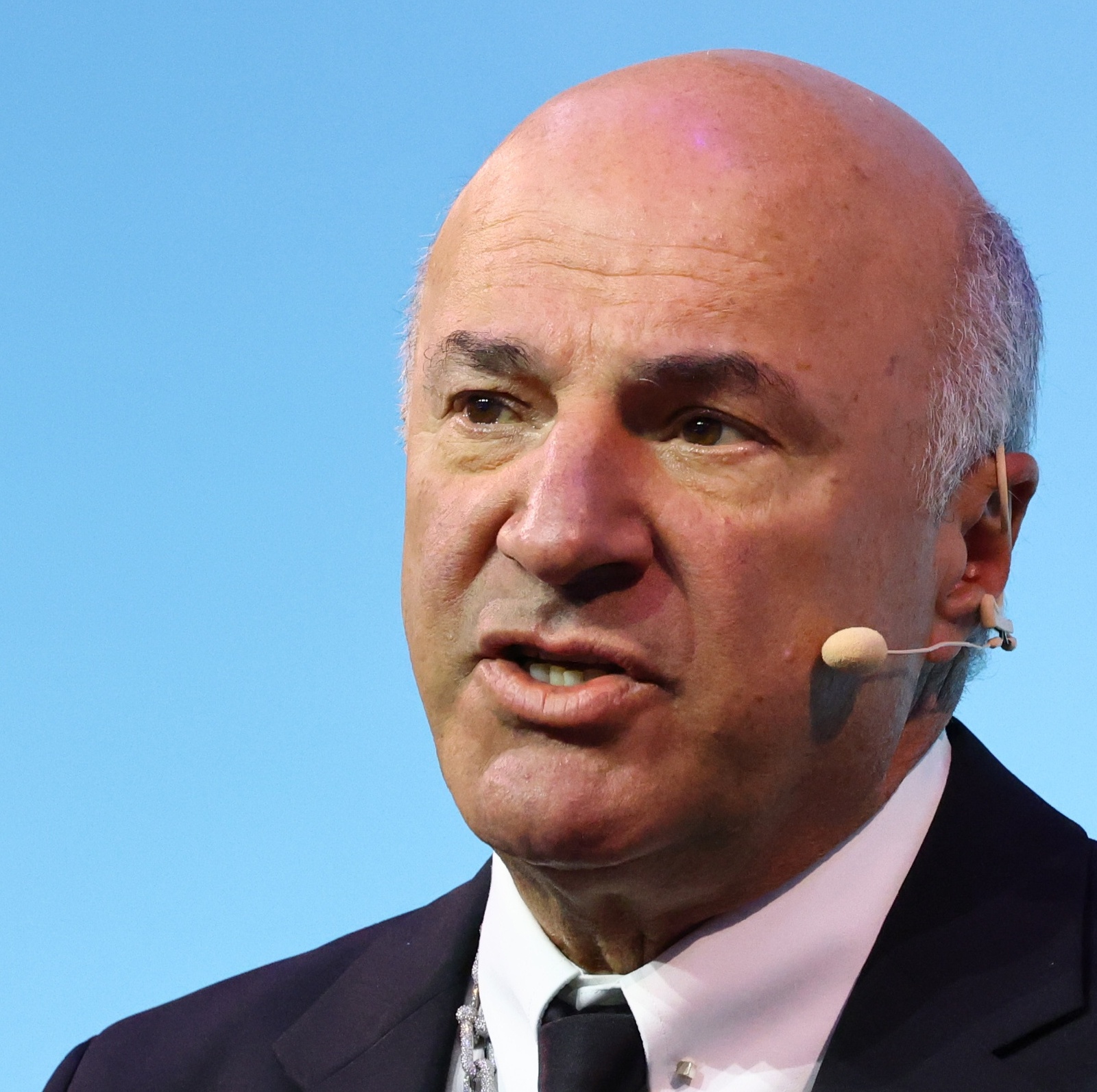 A close-up photo of Kevin O'Leary, speaking on stage at an event