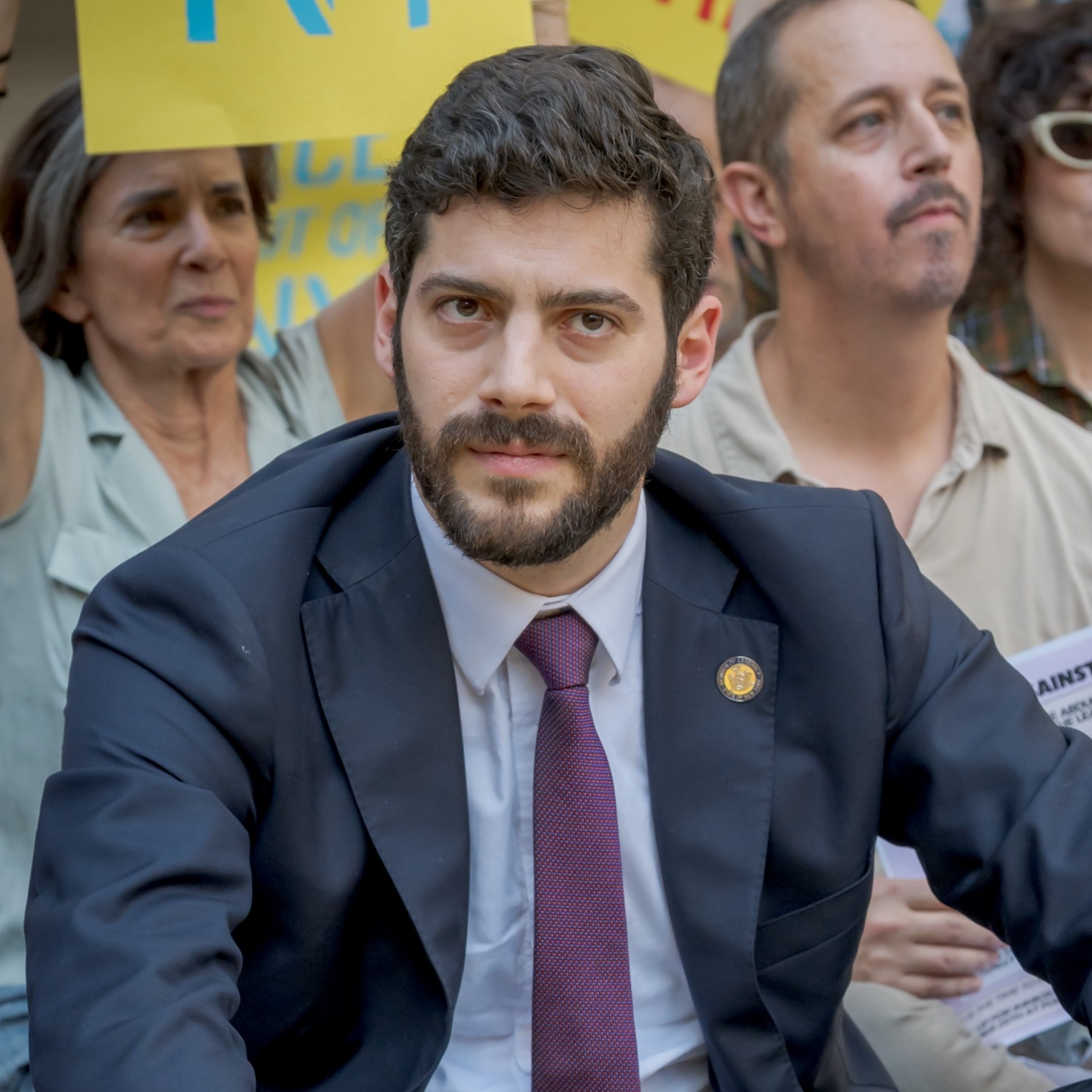 A side by side image of assemblymember Alex Bores seen at a protest alongside an image of California Governor Gavin Newsom speaking onstage at an event.
