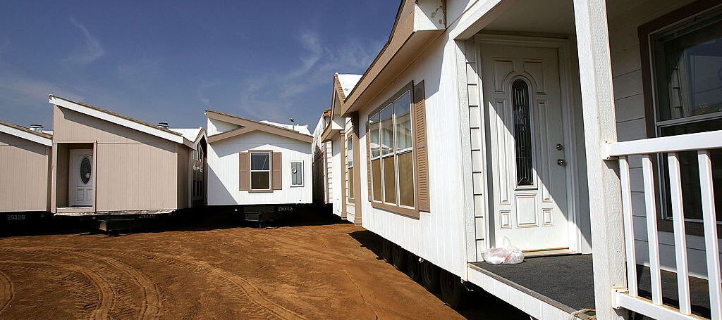 Travel trailers sit on a lot of land awaiting shipment