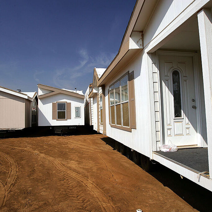 Travel trailers sit on a lot of land awaiting shipment