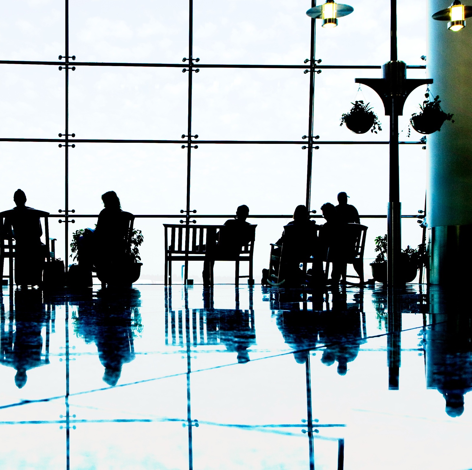 A high-contrast photo of people waiting in a premium airport lounge