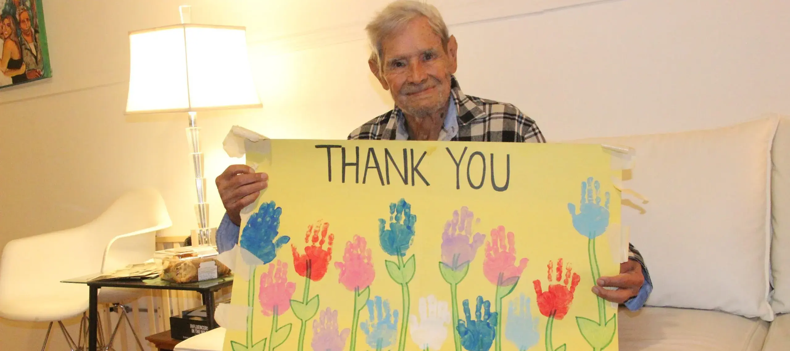 Luis Ramos holds a handmade "Thank you" poster made by children from a local daycare in Jersey City.