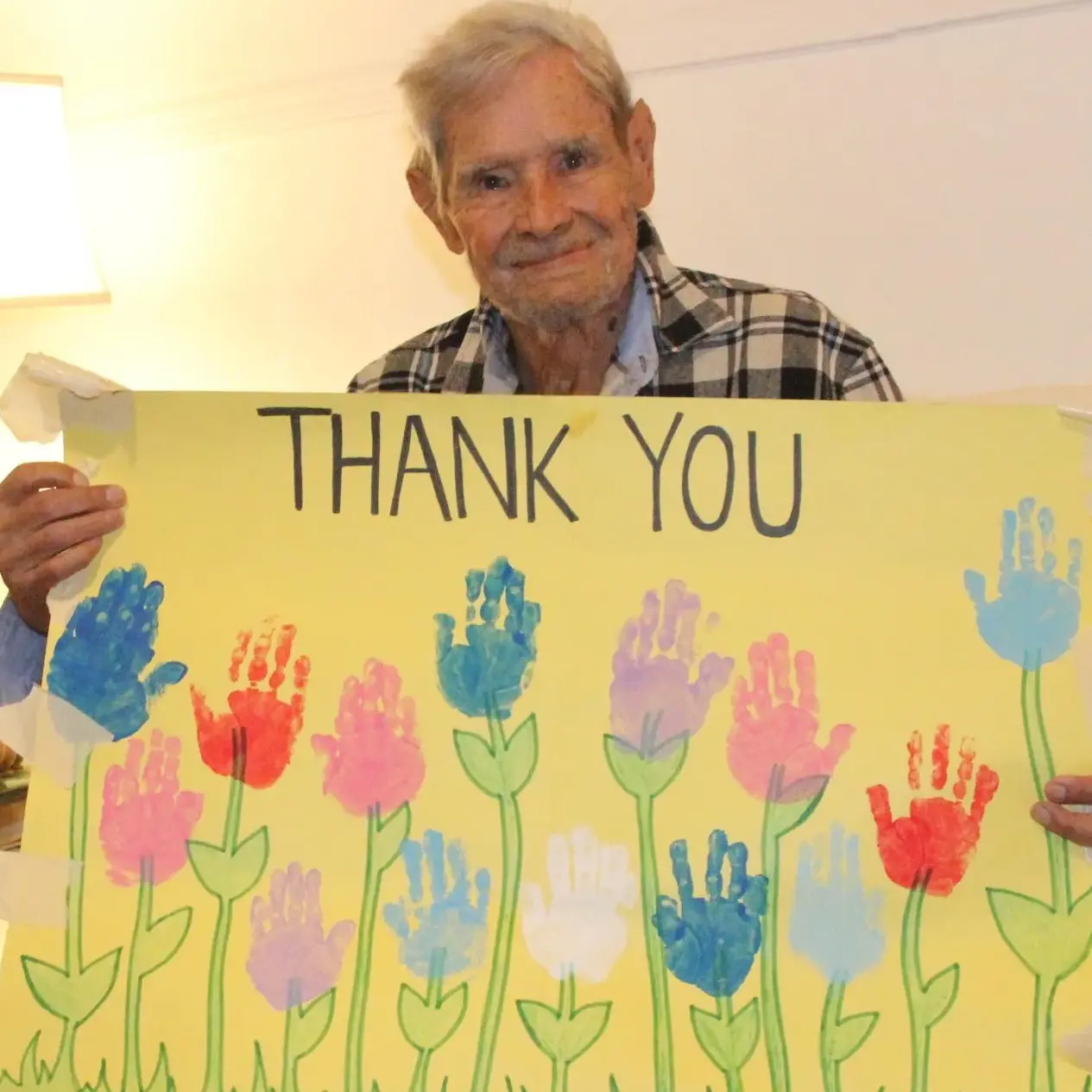 Luis Ramos holds a handmade "Thank you" poster made by children from a local daycare in Jersey City.