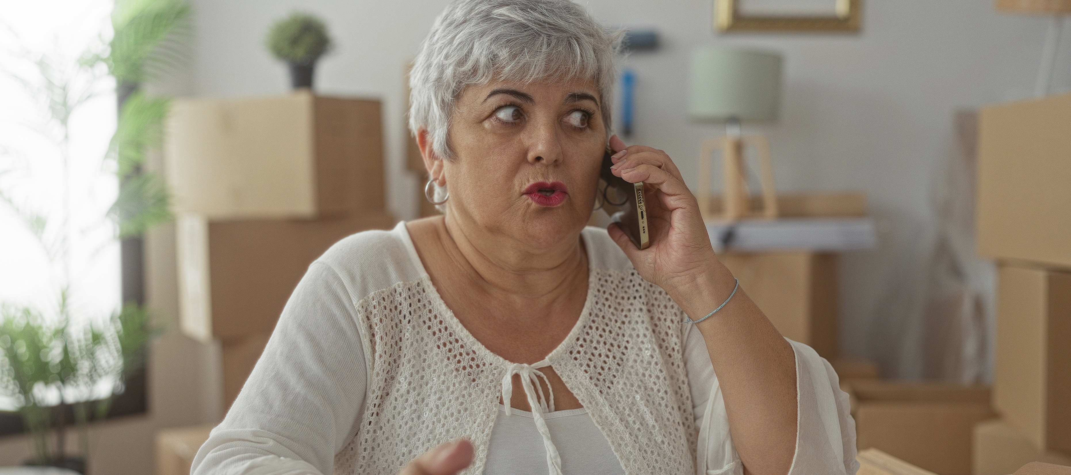 Woman holding phone to ear and gesturing with hand.