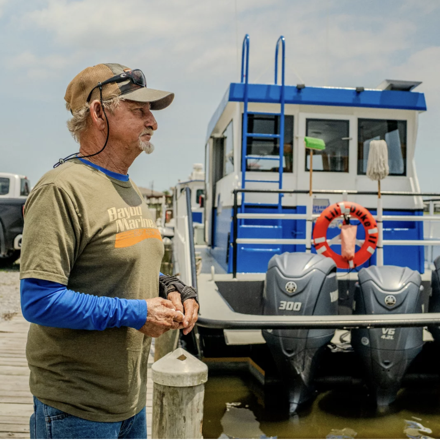Acy Cooper, a gulf shrimper, is photographed at Myrtle Grove Marina during his lunch break on May 15, 2026.