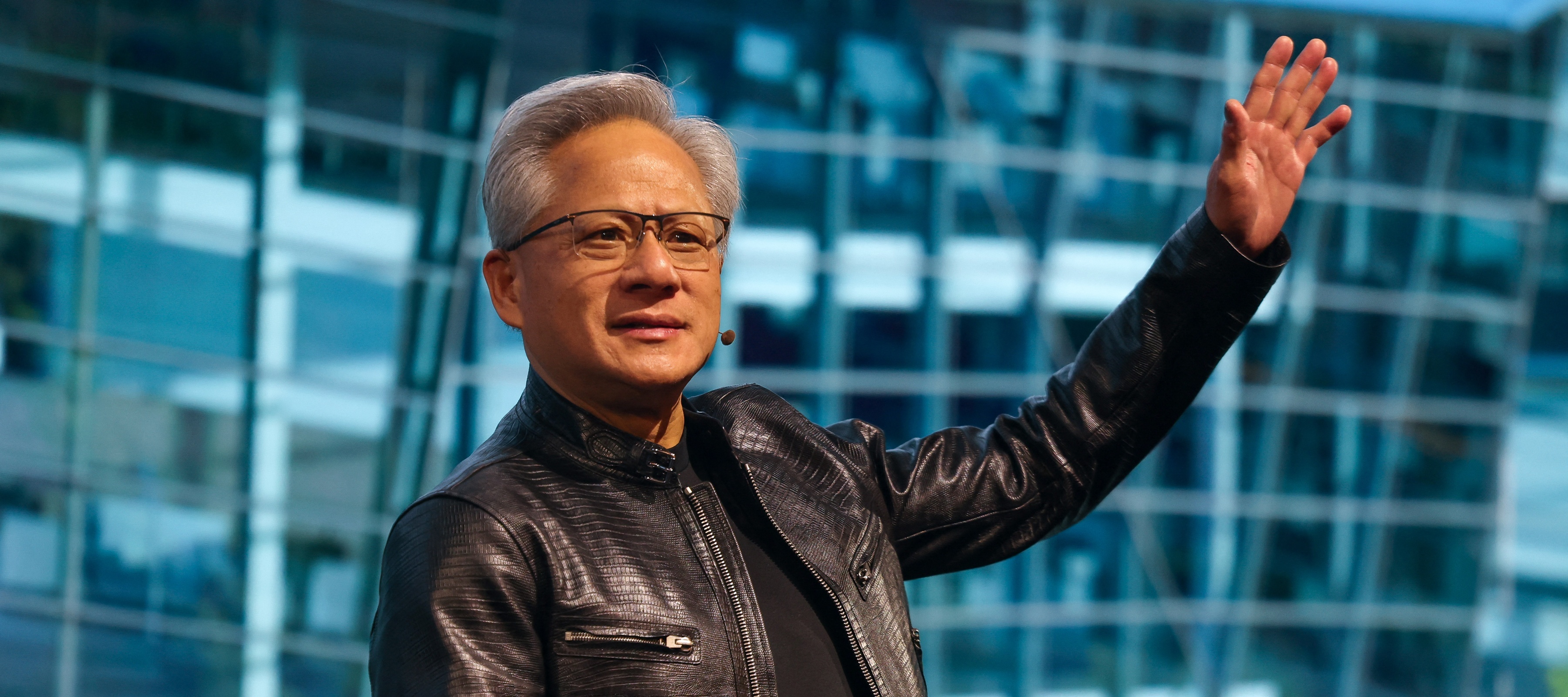 Nvidia CEO Jensen Huang lifts his arm and waves