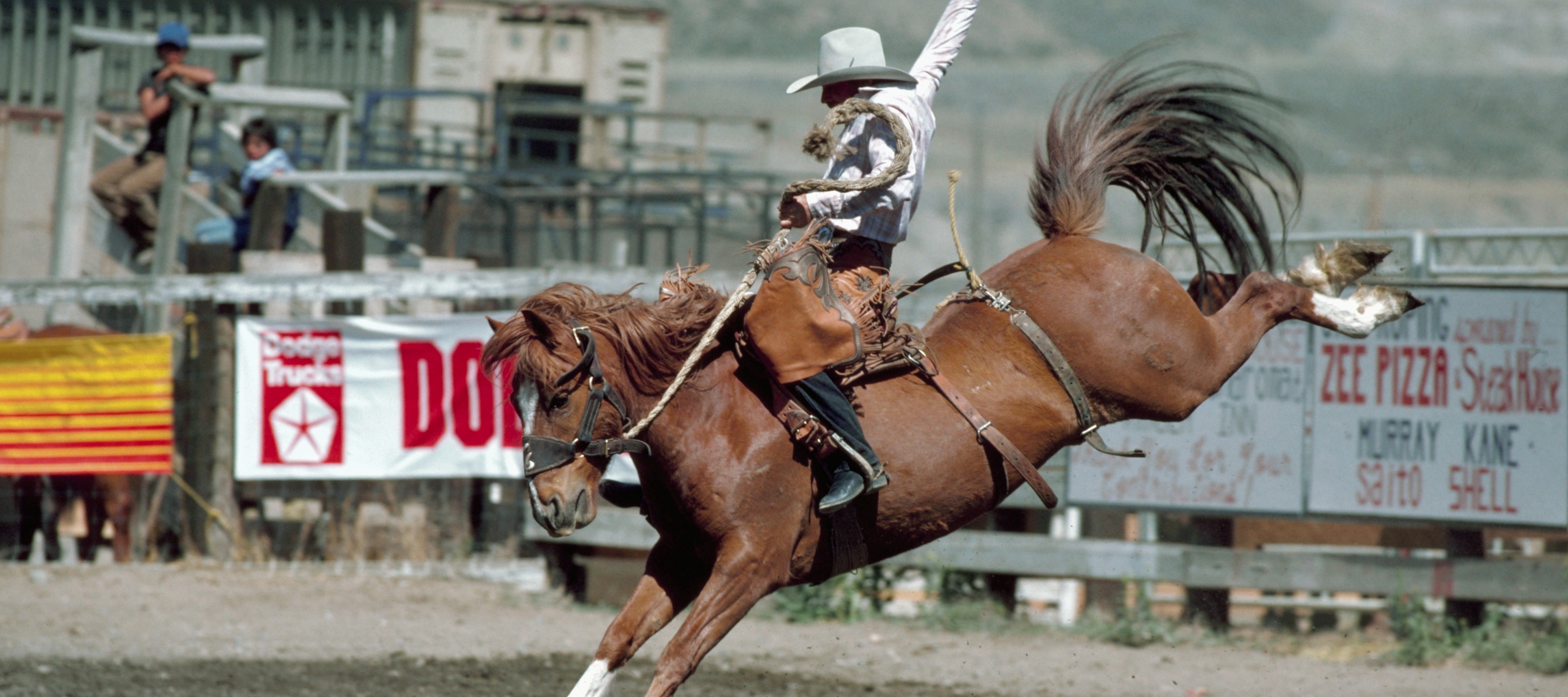 A man holding onto a bucking bronco