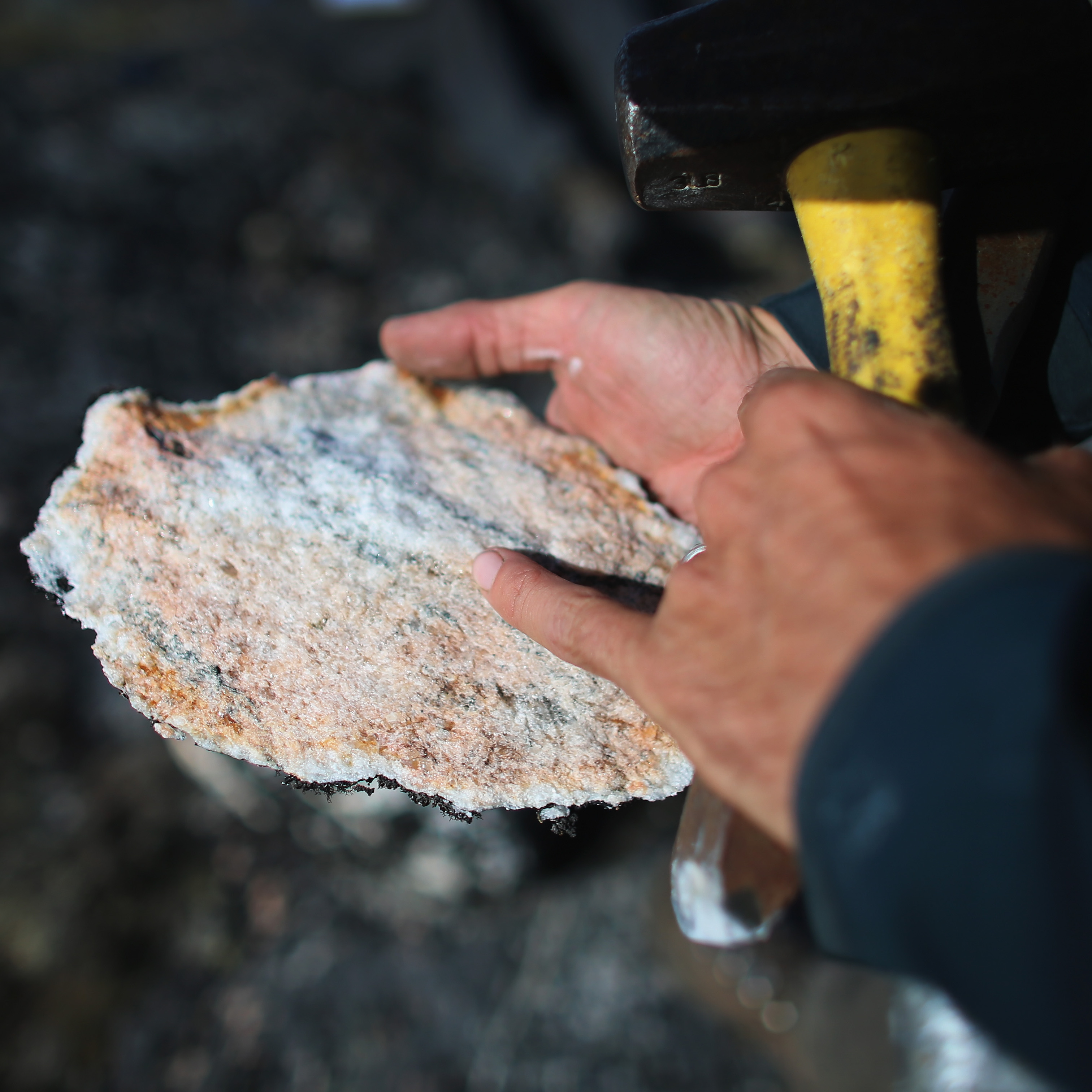 Jason Briner, with the University of Buffalo, Department of Geology, looks at a sample of granite.