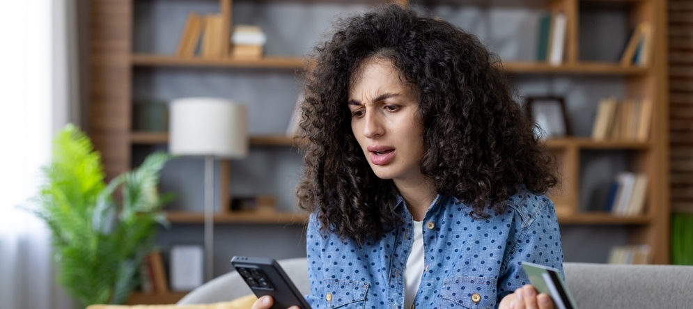 Woman feeling frustrated and confused while looking at her credit card bill.