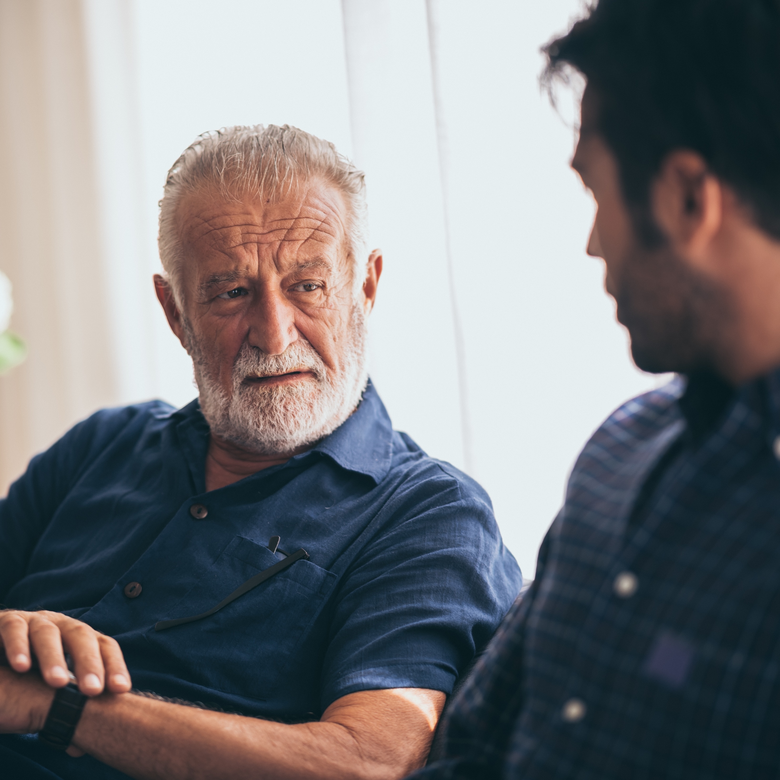older man looking at son touching his watch
