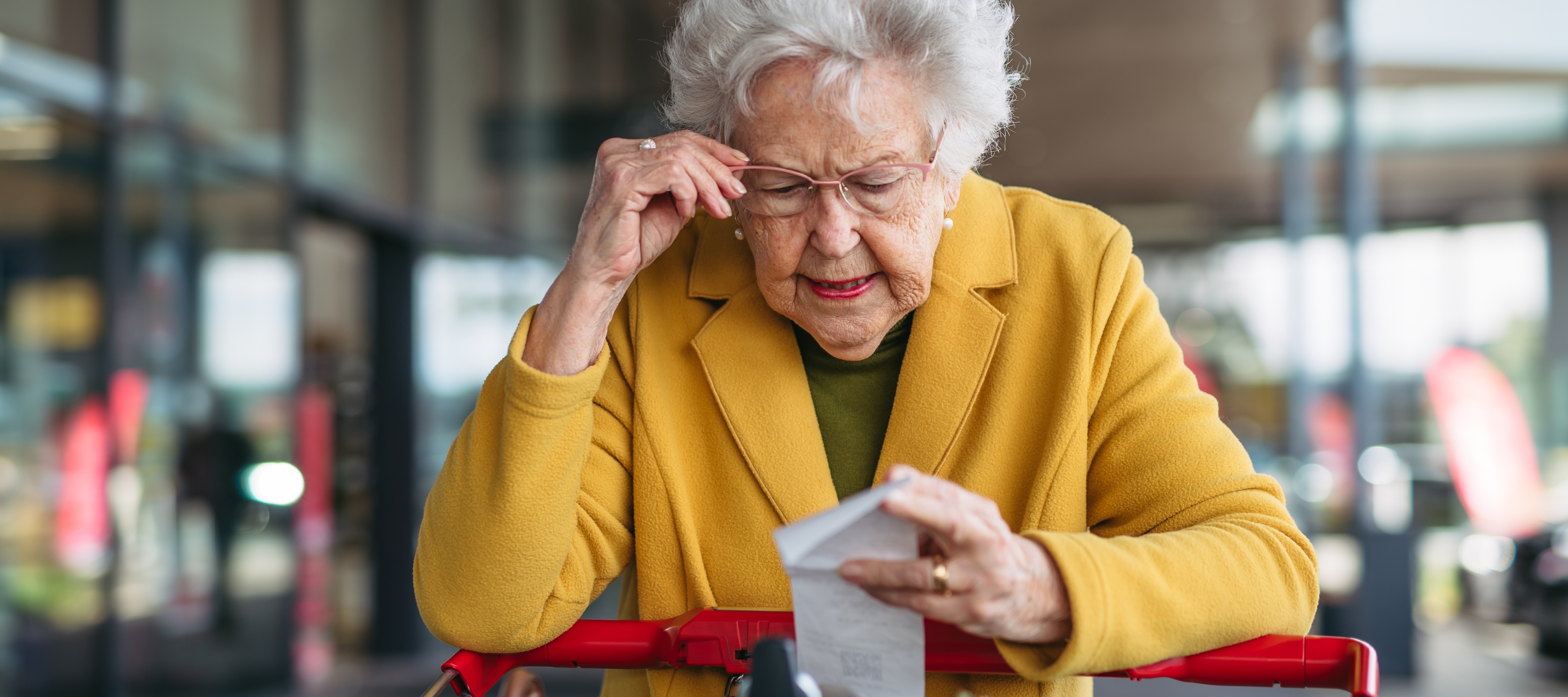Senior woman looking at grocery receipt