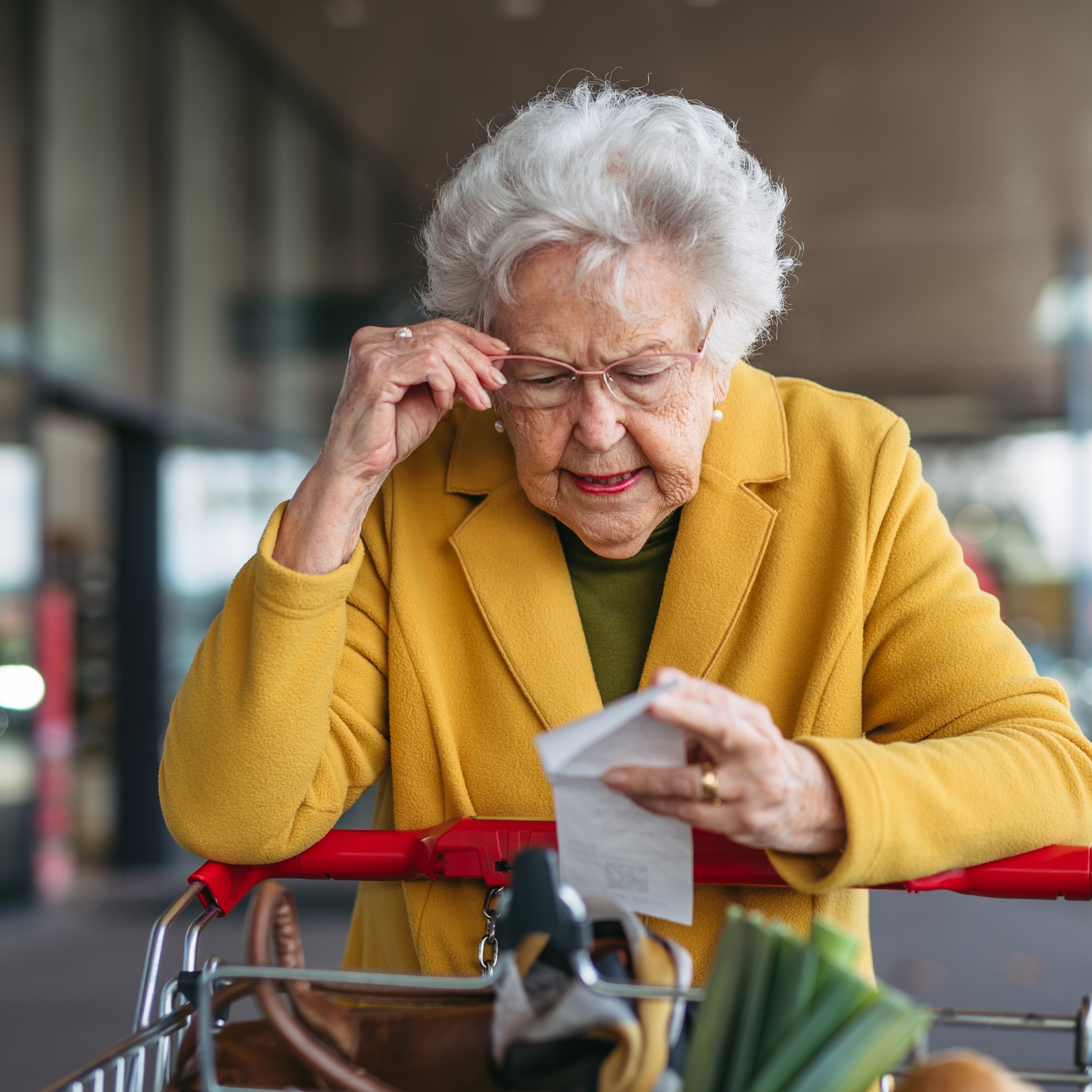 Senior woman looking at grocery receipt