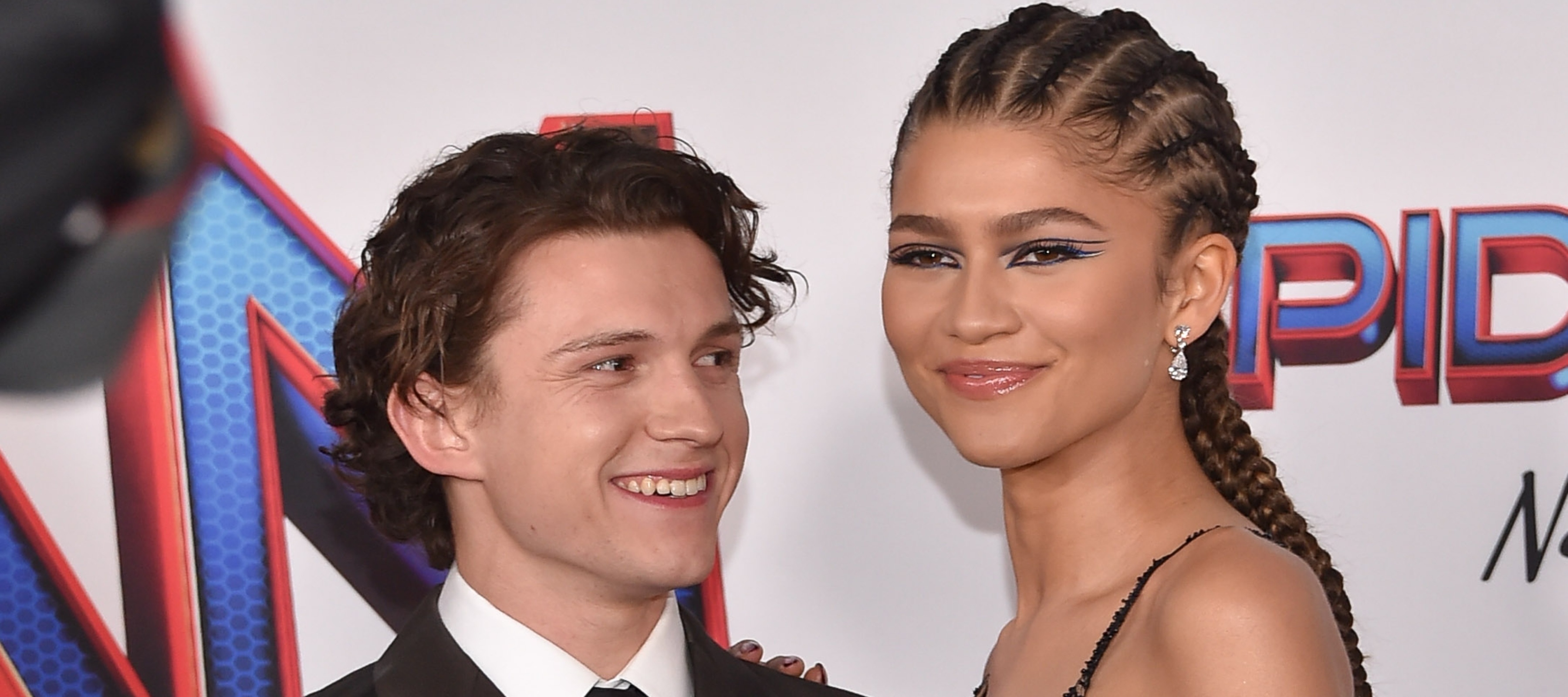 Tom Holland smiles at Zendaya as they share the red carpet for "Spider-Man: No Way Home"