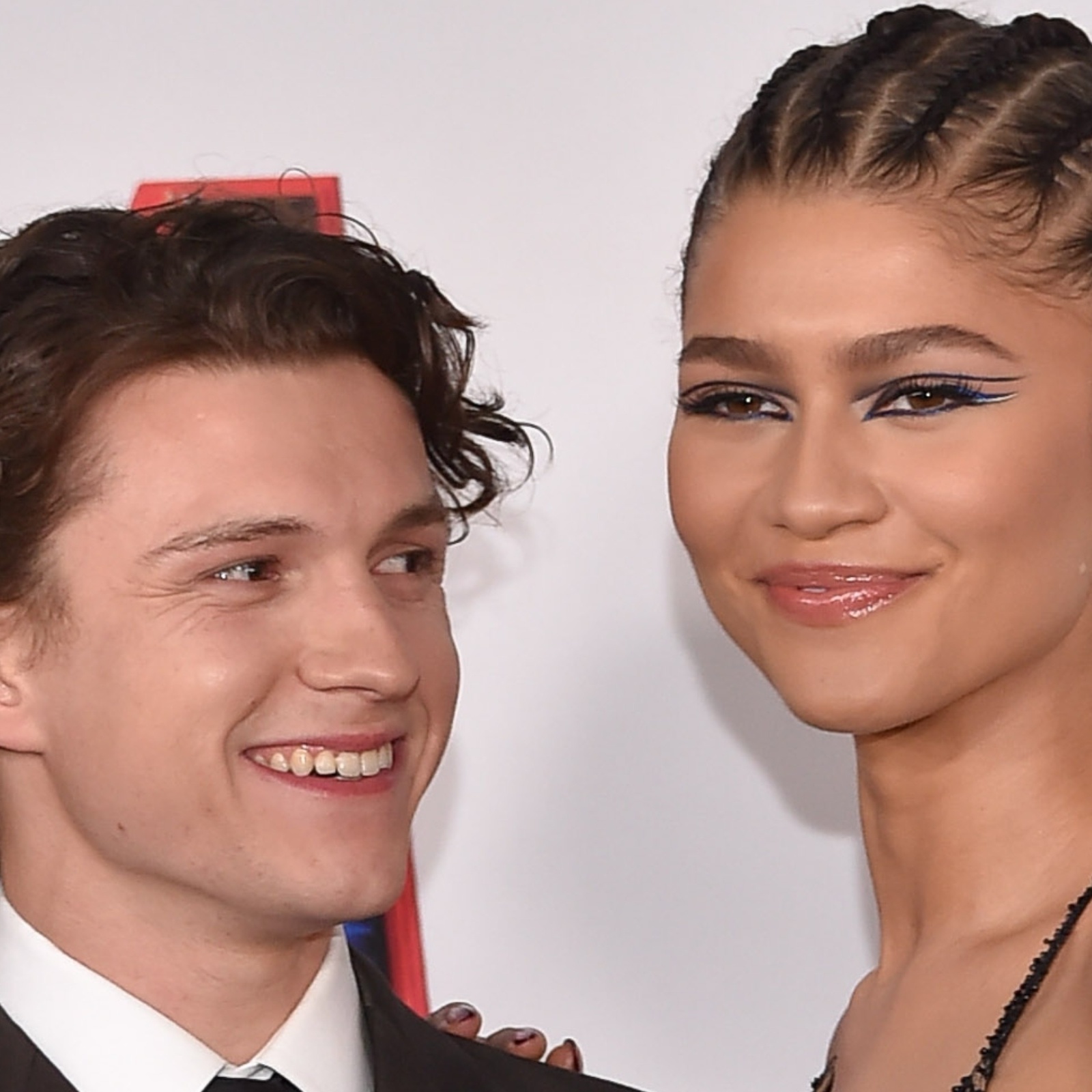 Tom Holland smiles at Zendaya as they share the red carpet for "Spider-Man: No Way Home"