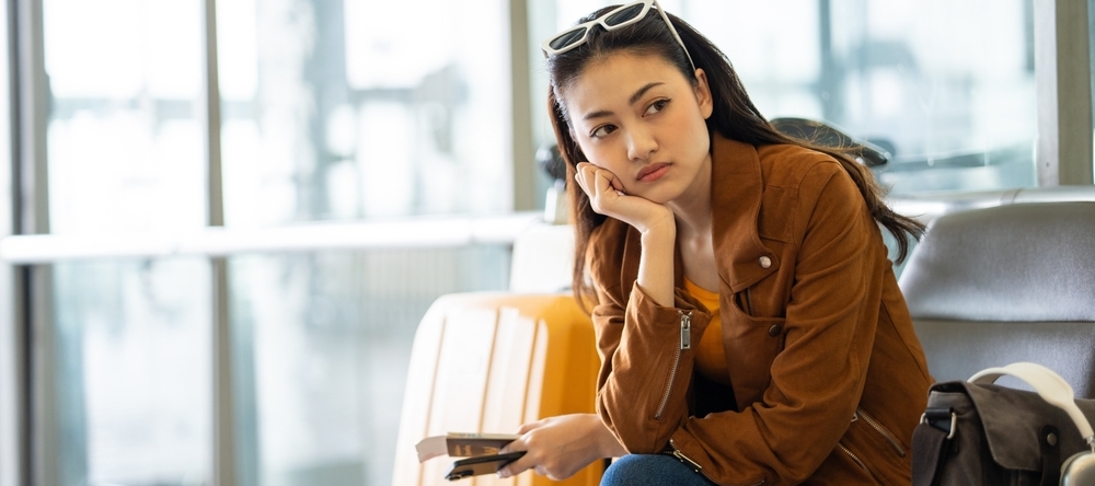A photo of a woman at an airport waiting to board her flight