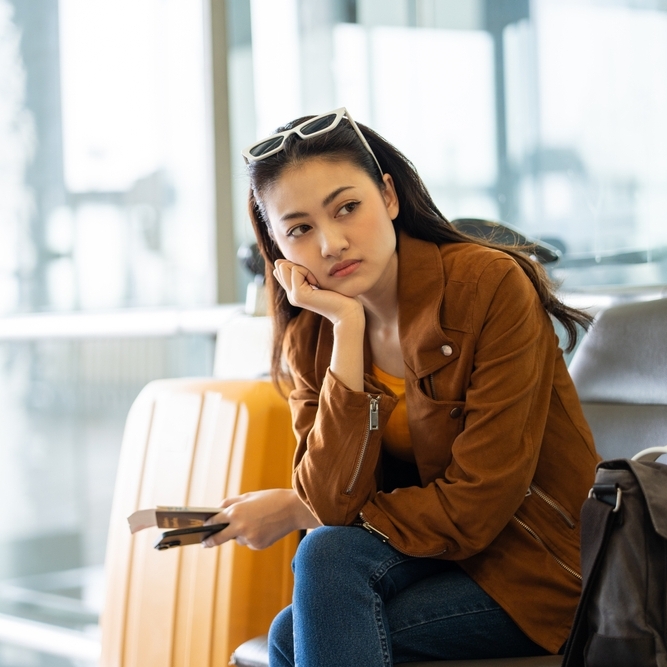A photo of a woman at an airport waiting to board her flight